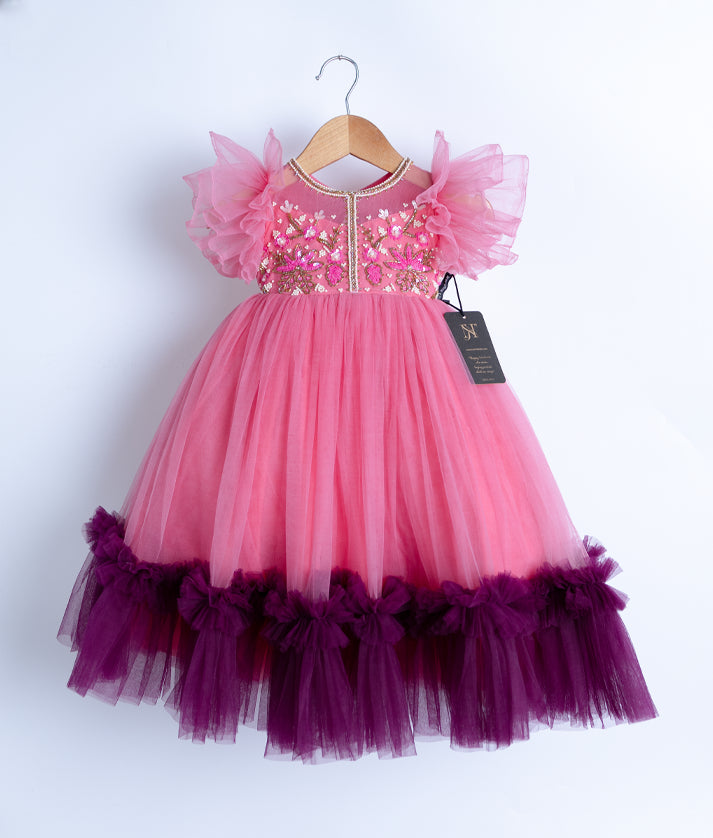 Front view of a full-length pink tulle net birthday gown with glittering handwork and butterfly sleeves.