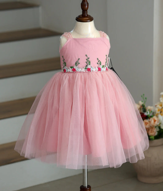 Front view of a pink tulle net frock with handworked detailing on the top.
