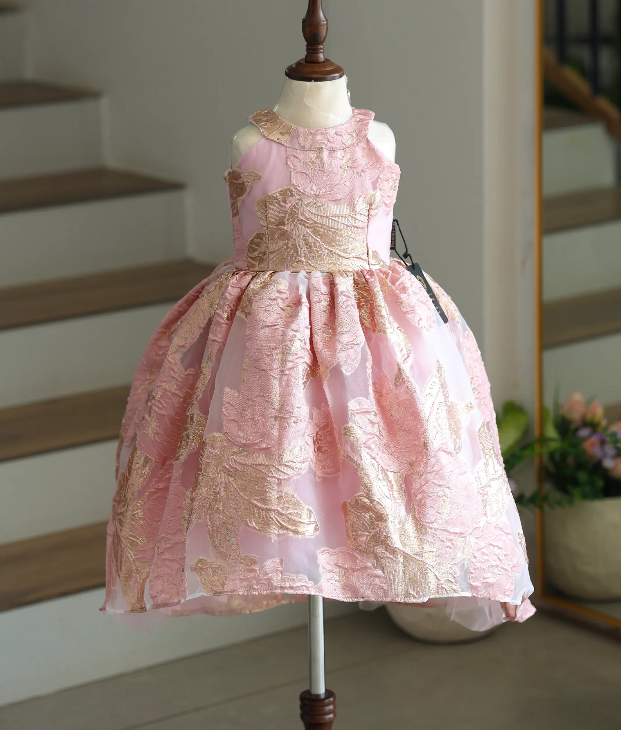 Front view of a pink Turkish organza frock with gold floral patterns and a high-low pattern.
