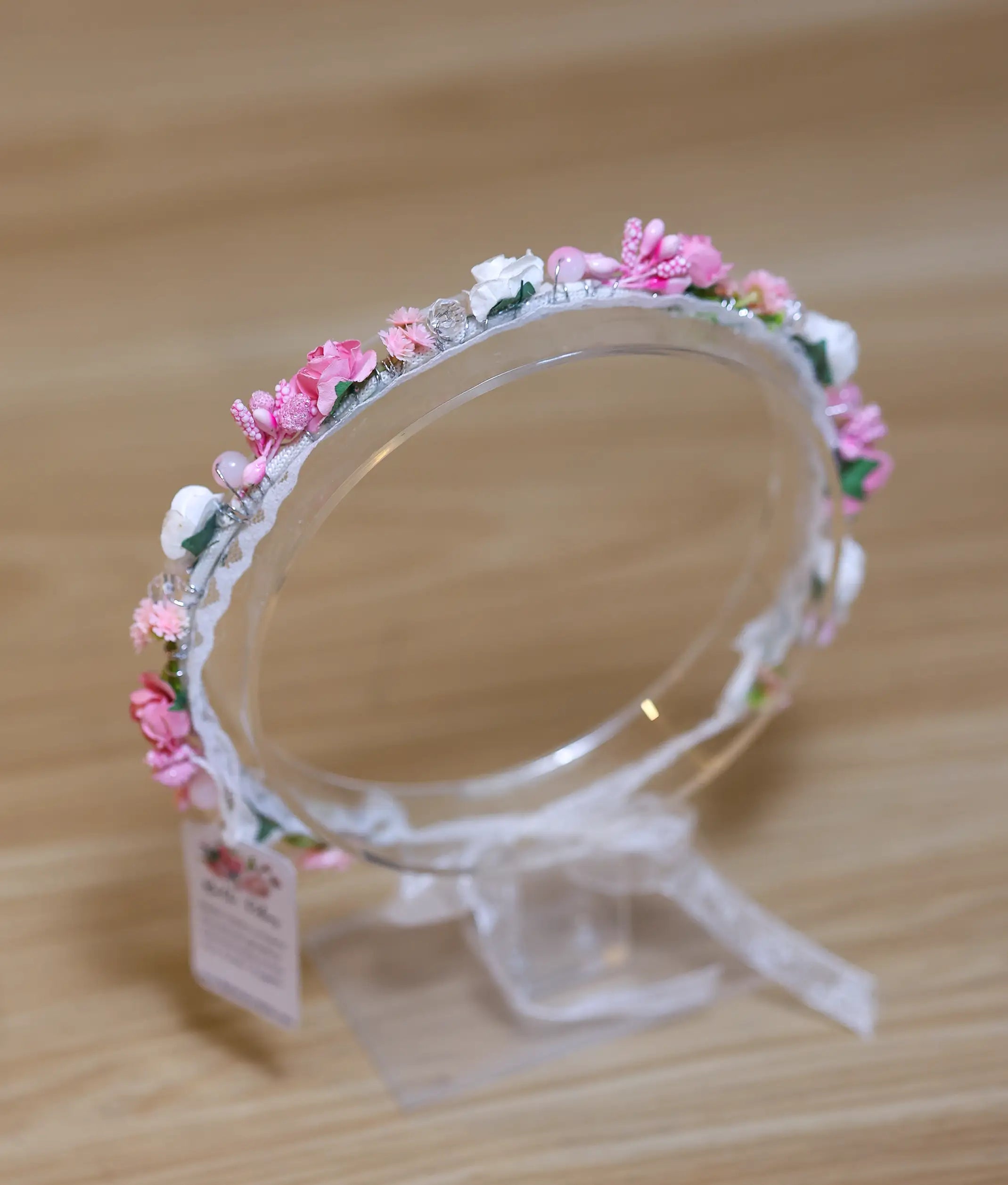 Close-up of the handcrafted pink flowers, white buds, and pearl bead detailing on the floral birthday crown