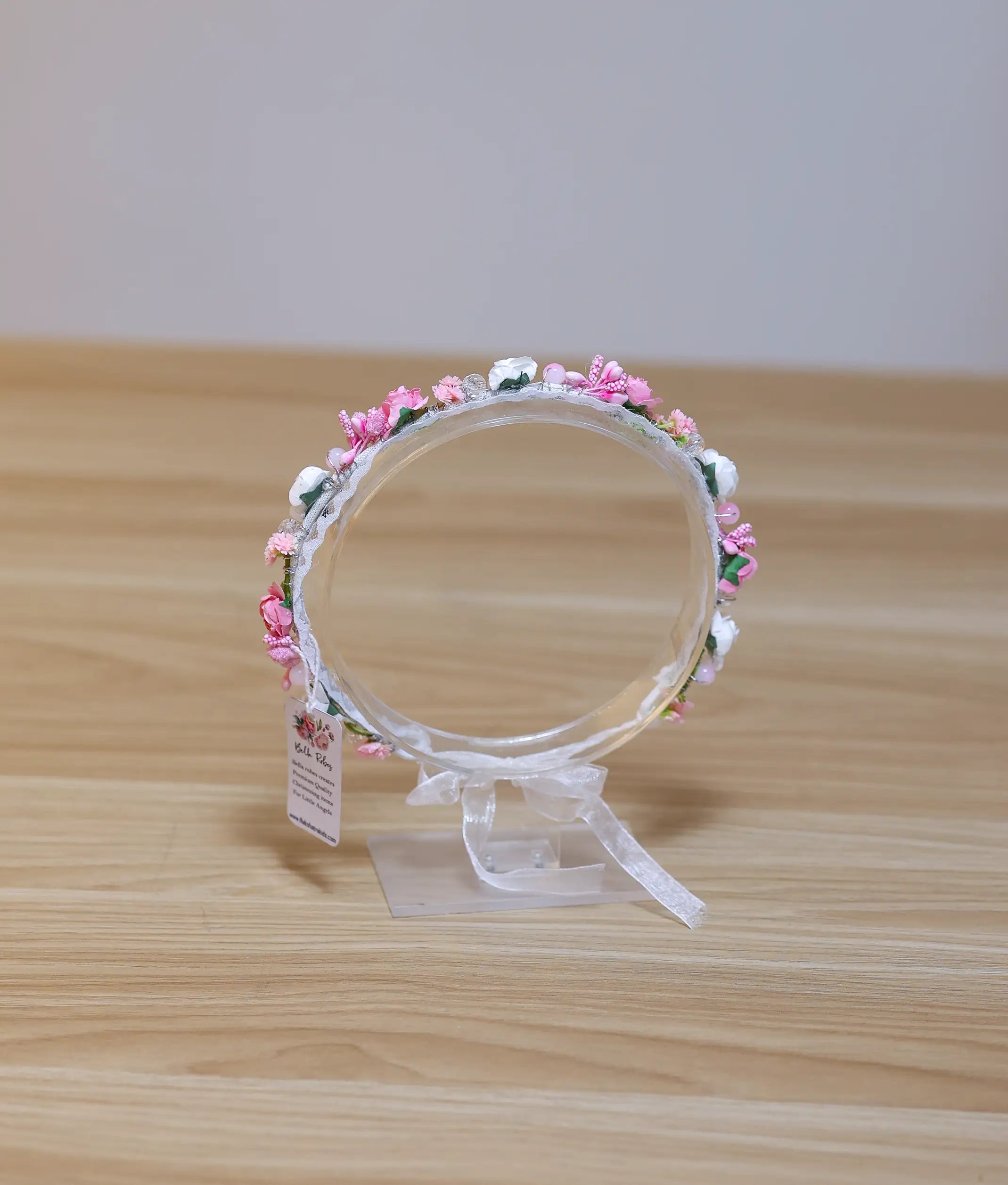 Front view of a pink and white floral tiara for baby girls featuring delicate blossoms and a lace-wrapped band