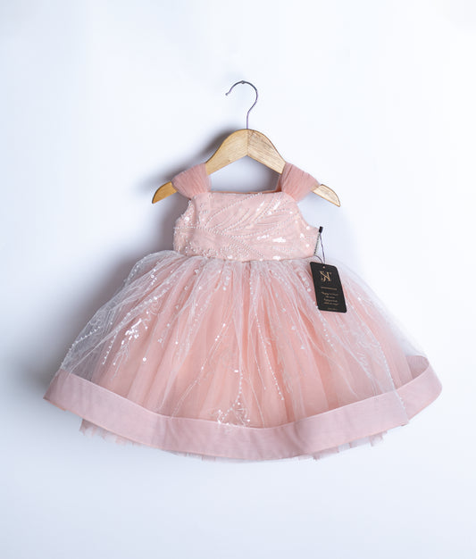 Front view of pink handworked birthday frock for baby girls with layered tulle and cap sleeves.