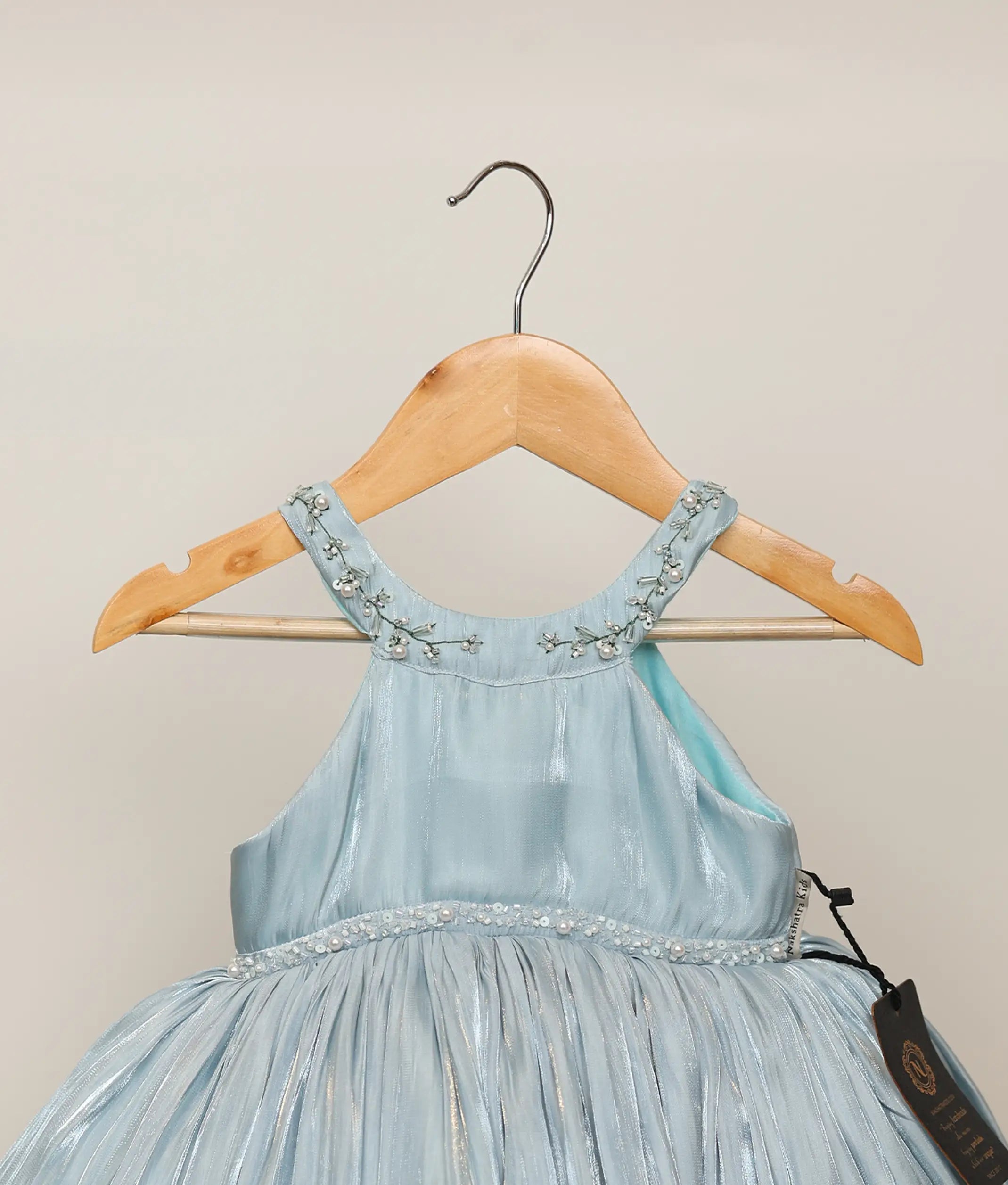 Close-up of the shimmering metallic lacer organza fabric and the intricate white and blue bead-and-stone handwork on the birthday dress