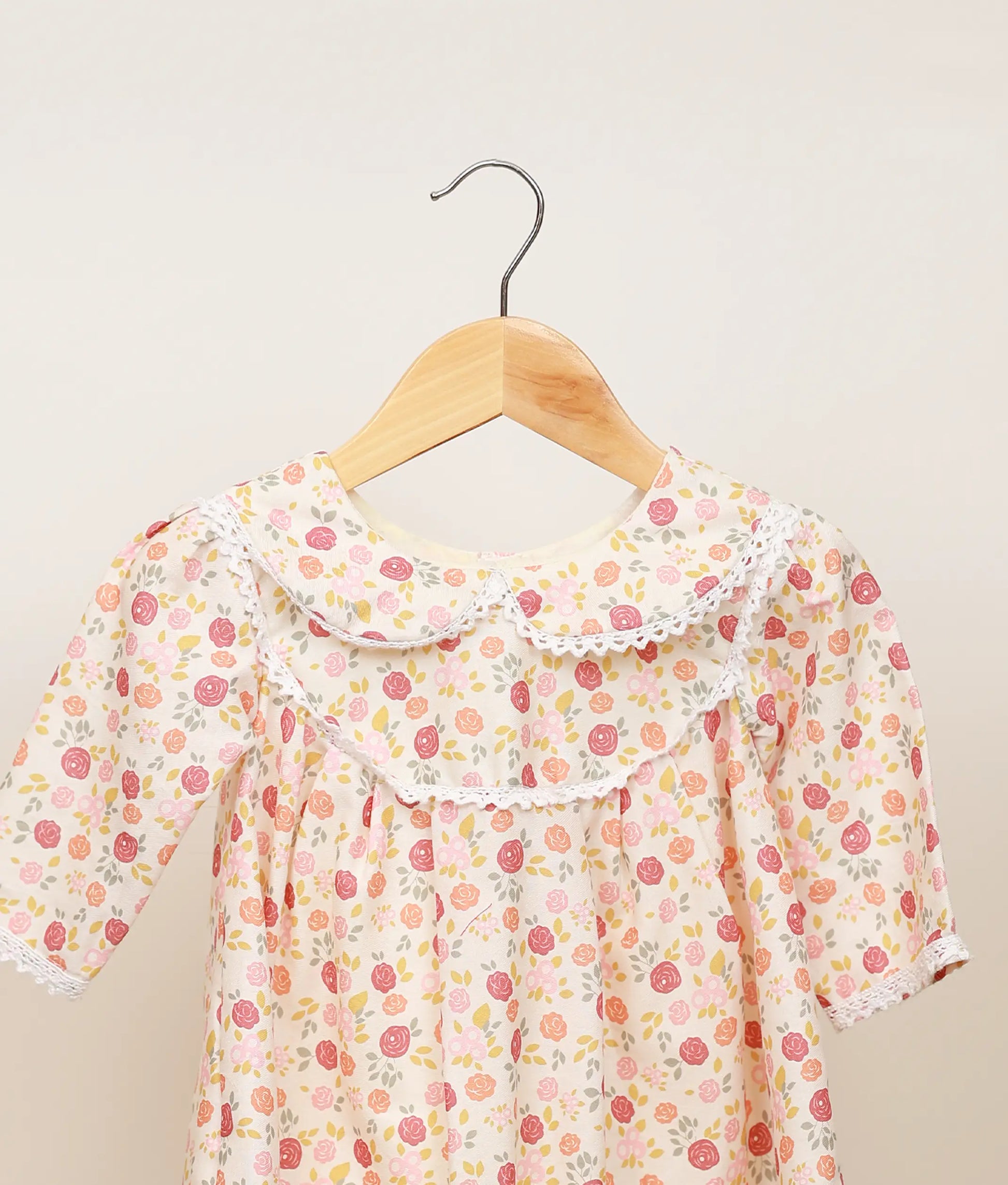 Close view of the printed cotton yoke and lace detailing around the round neckline of the dress.