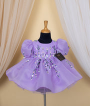 Purple frock for baby girl with floral embroidery and tulle skirt on black dress form mannequin