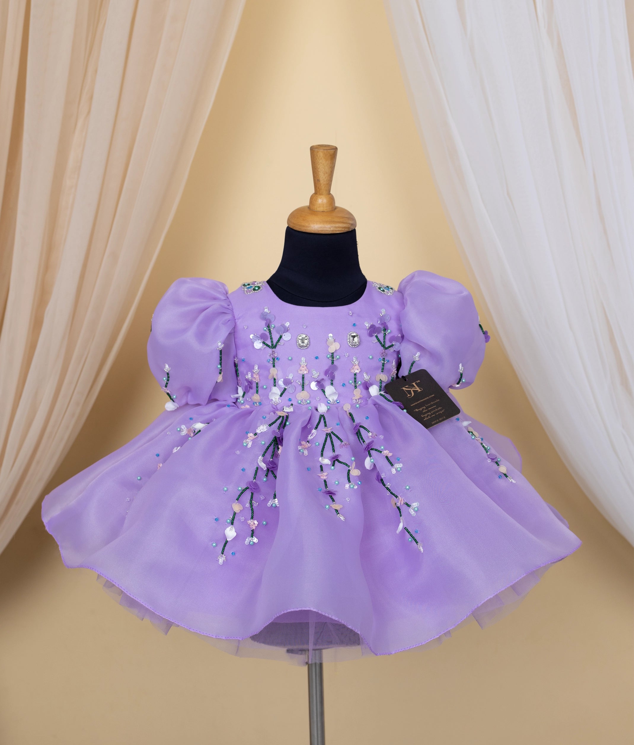 Purple frock for baby girl with floral embroidery and tulle skirt on black dress form mannequin