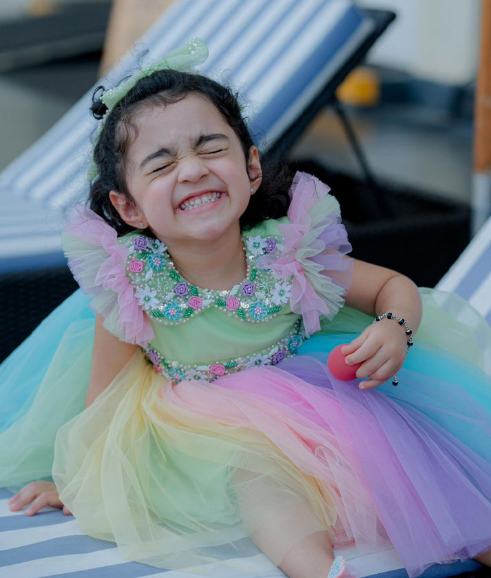 Close-up of the delicate floral embroidery, beadwork, and floral appliqués on the Peter Pan collar of the rainbow dress