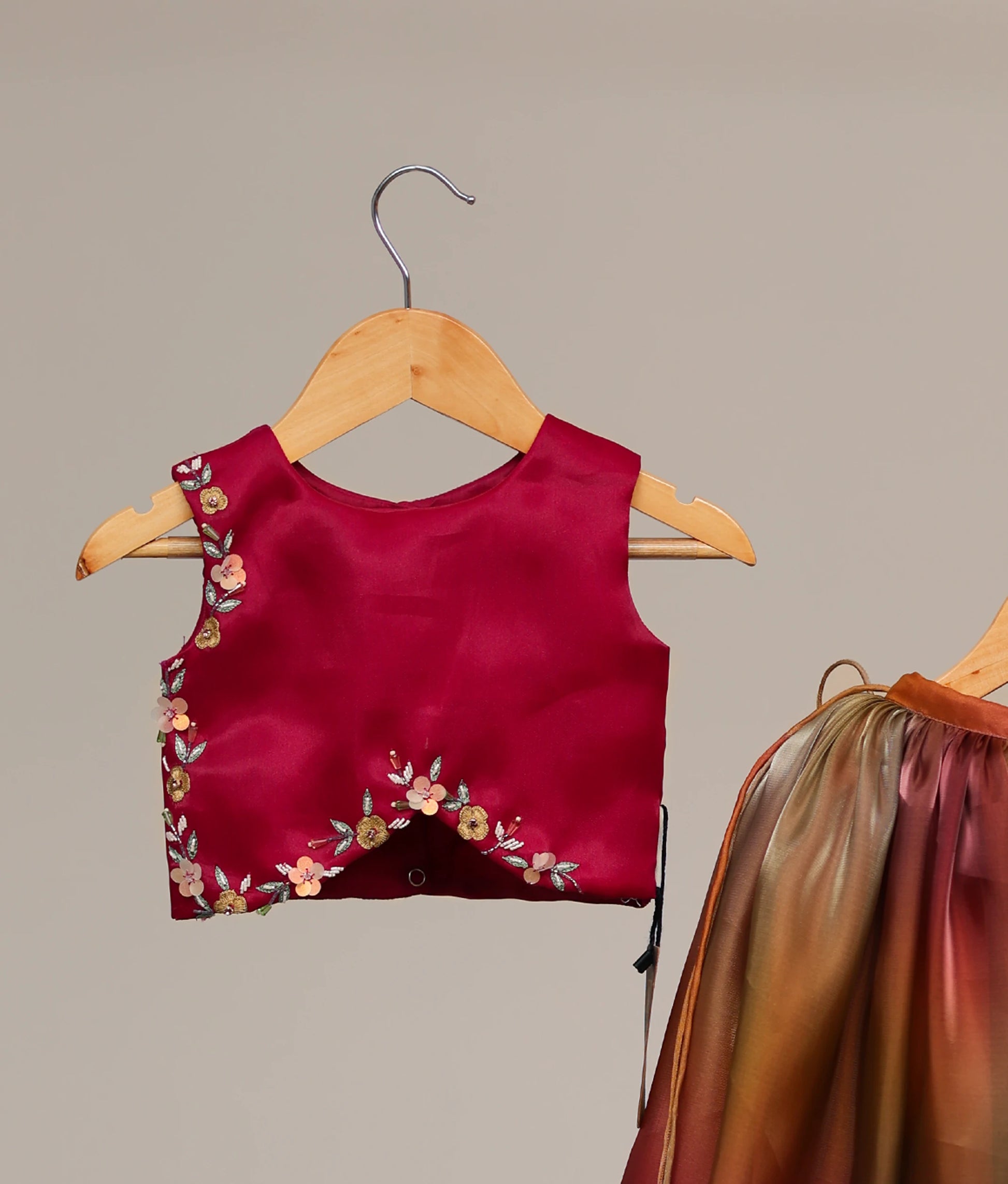 Close-up of the intricate floral handwork on the vibrant rani pink organza short top