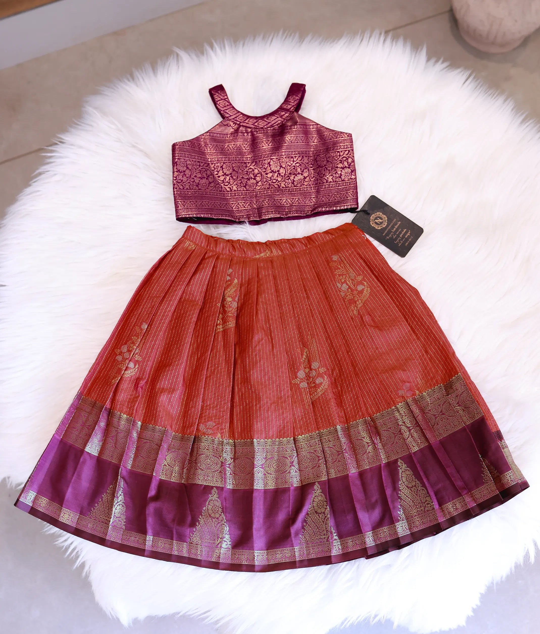 Front view of a magenta and red Kanchipuram silk skirt and top with halter neck.