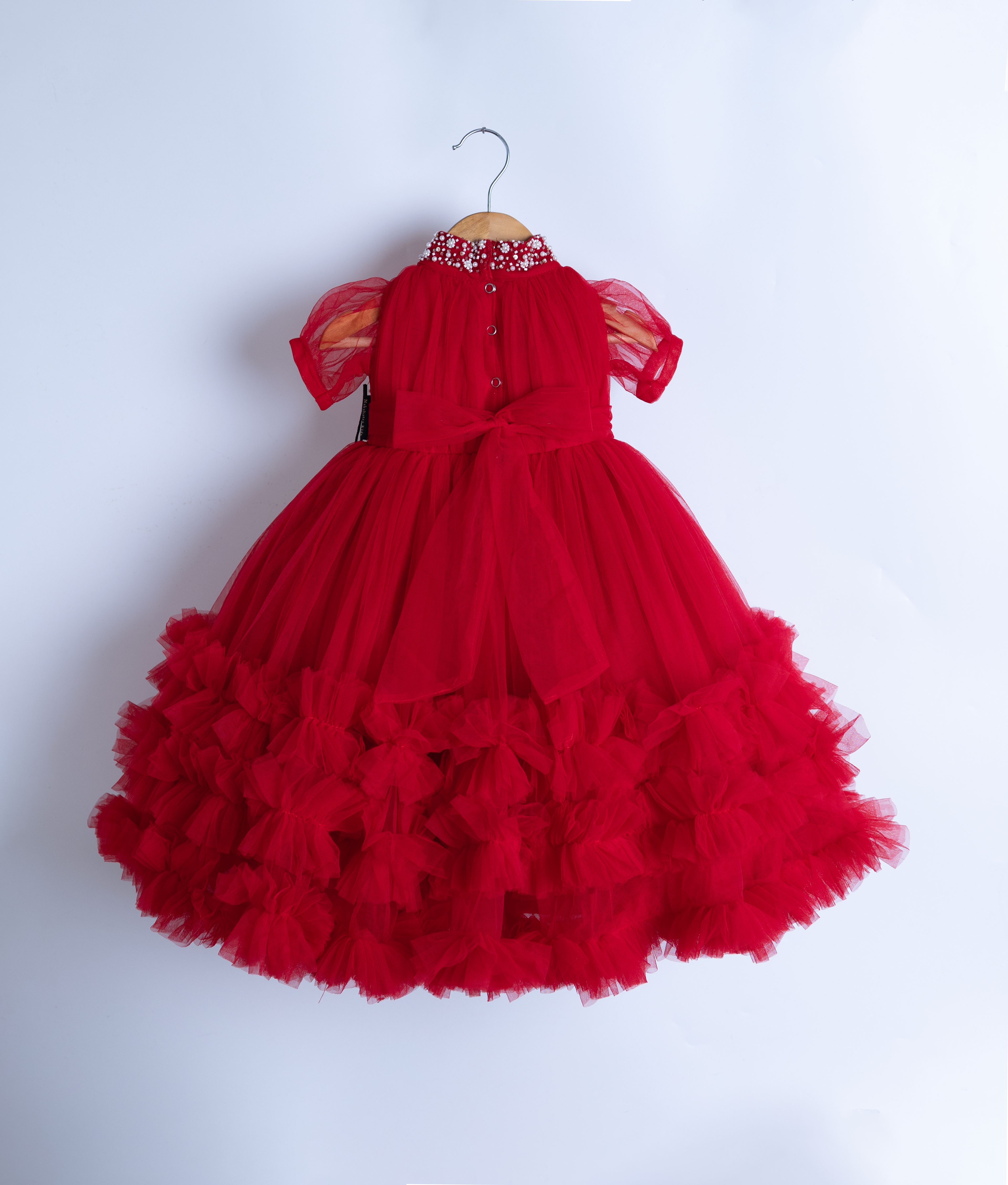 Back view of red fluffy baby girl dress on hanger