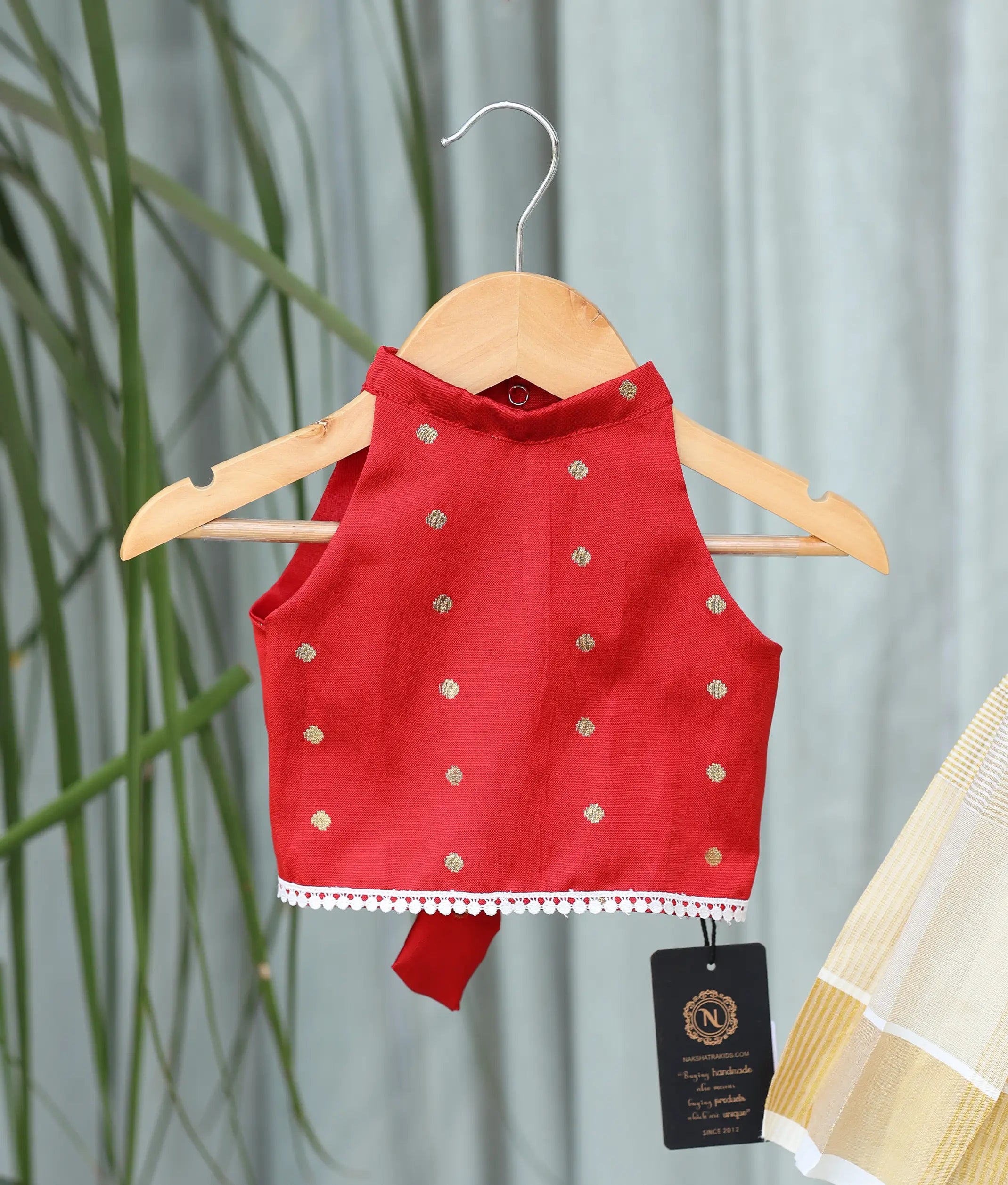 Close-up showing the golden polka dots on the red top.