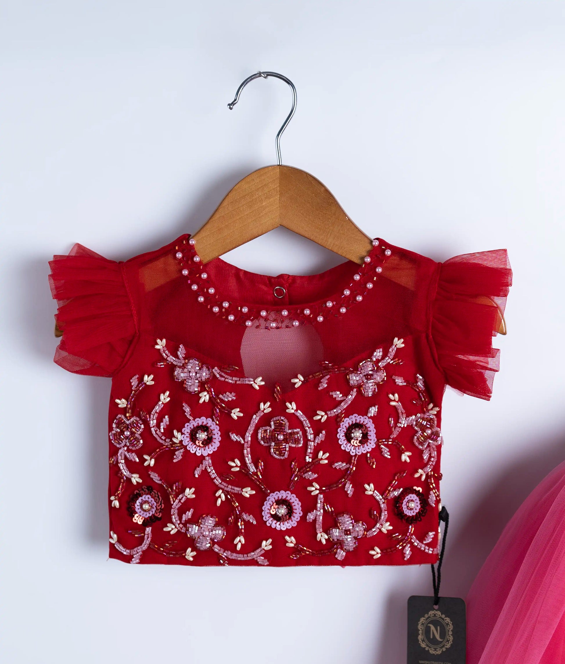 Close-up of red swan theme dress showing intricate handmade applique work and embroidery on bodice