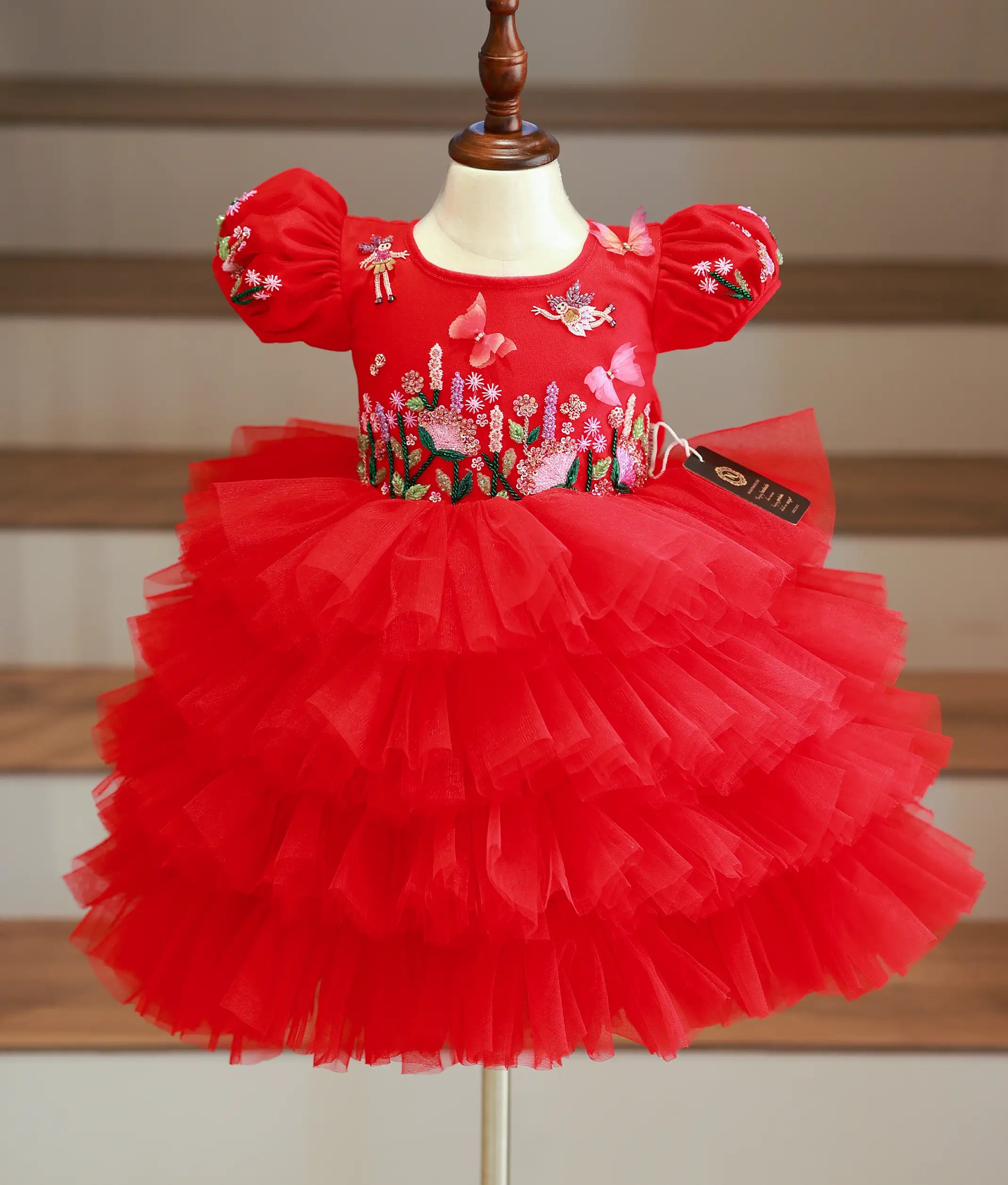 Front view of a red tulle butterfly theme birthday dress for girls with tiered ruffles and handwork