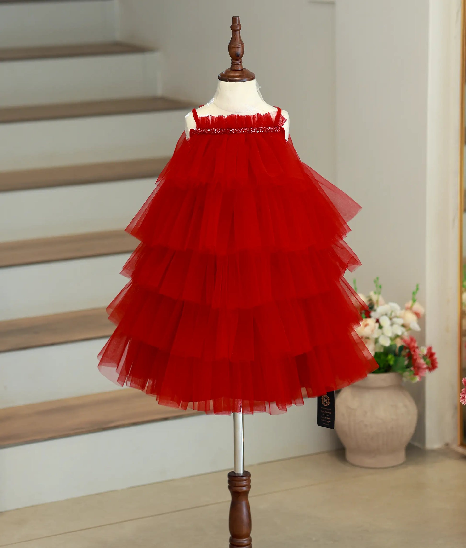 Front view of a red birthday frock for baby girls featuring a step-pattern tulle net design.