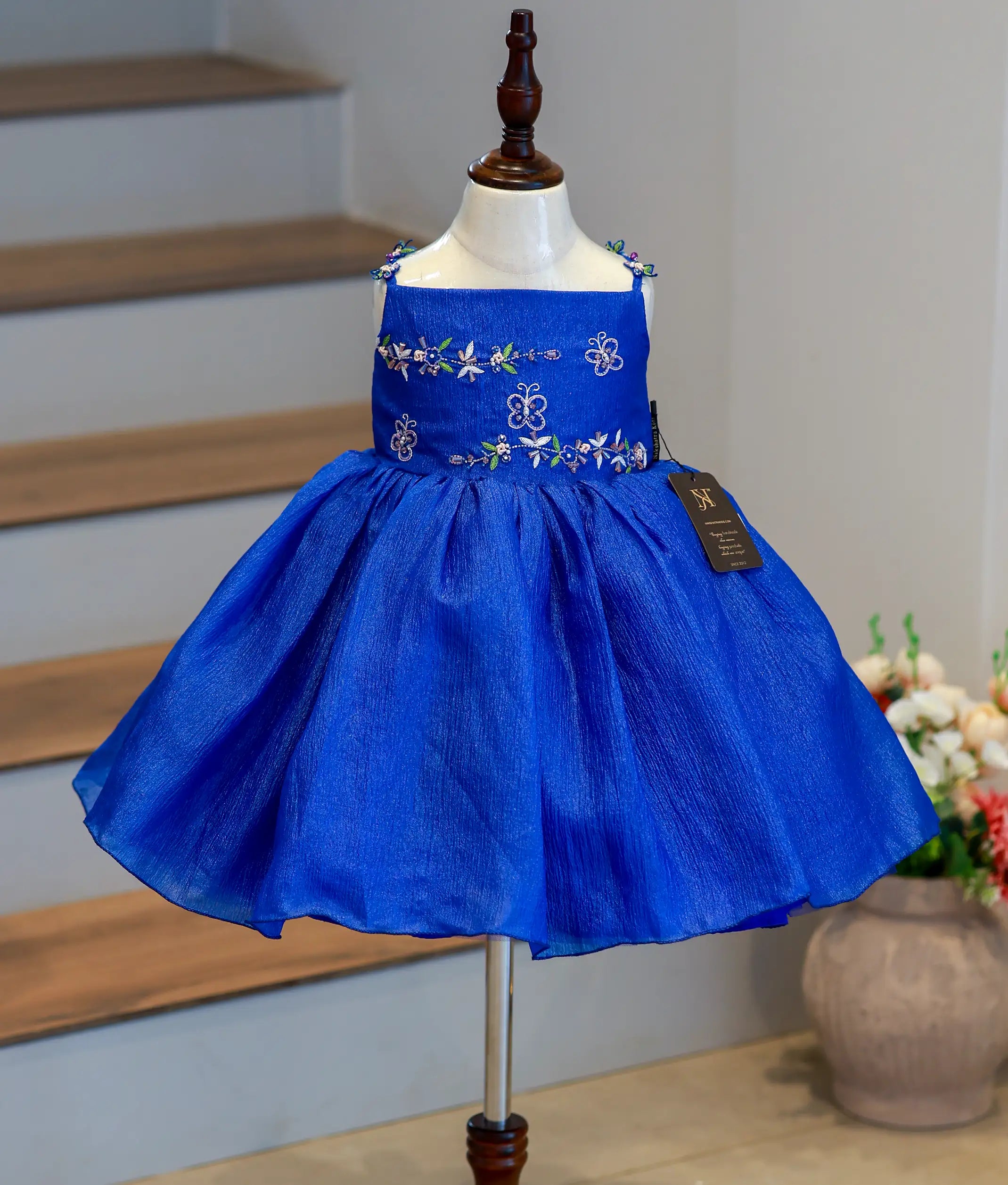 Front view of a royal blue crush organza flower girl theme frock with floral embroidery and a flared skirt