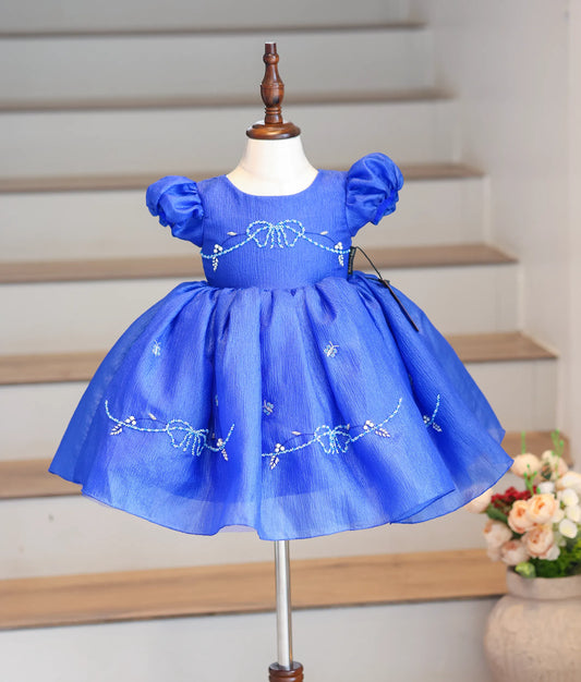 Front view of a royal blue halter neck frock in crush organza with floral handwork.