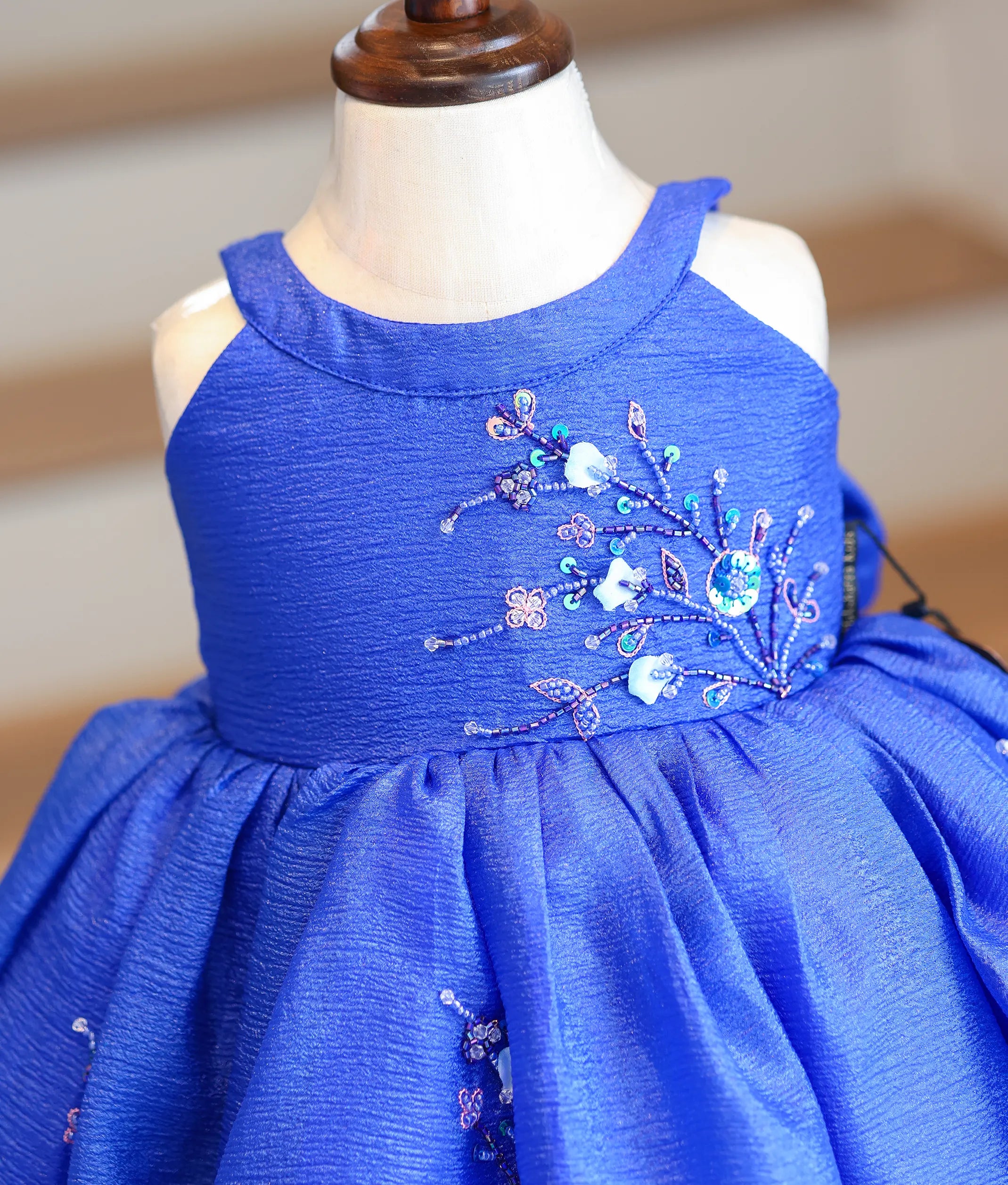 Close-up of the silver and light blue beadwork on the royal blue bodice and scalloped hem.