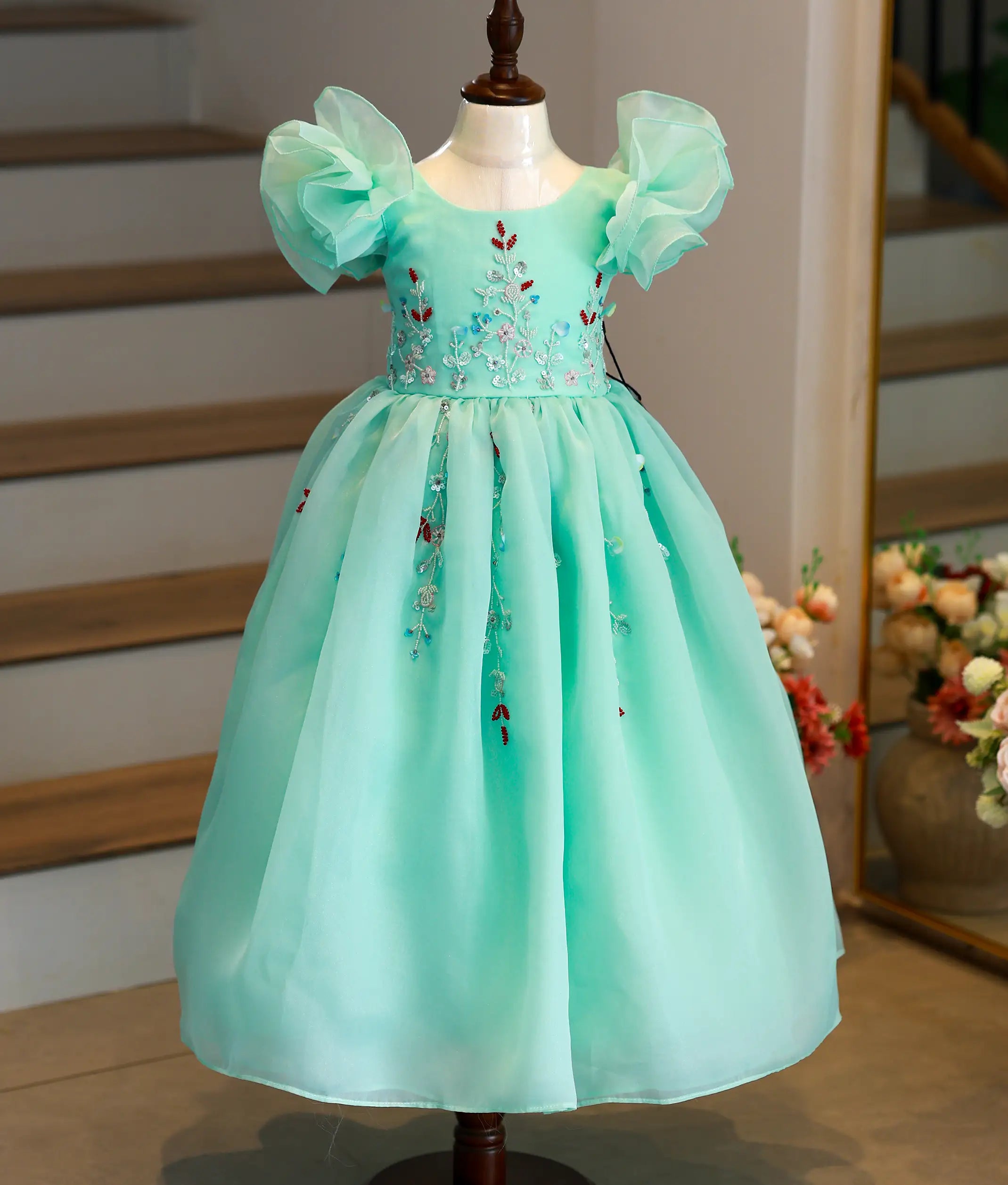 Front view of sea green handworked birthday gown for baby girls with a full-length gathered skirt