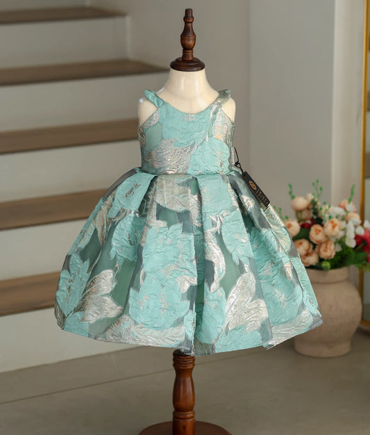Front view of a sea green Turkish organza frock with silver floral patterns and box pleats.
