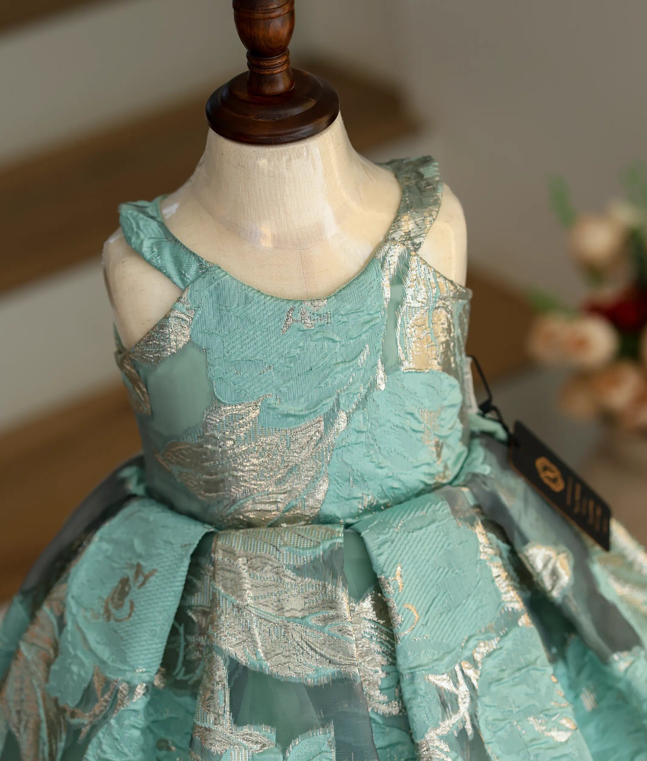 Close-up of the silver floral patterns and halter neck straps on the Turkish organza fabric.