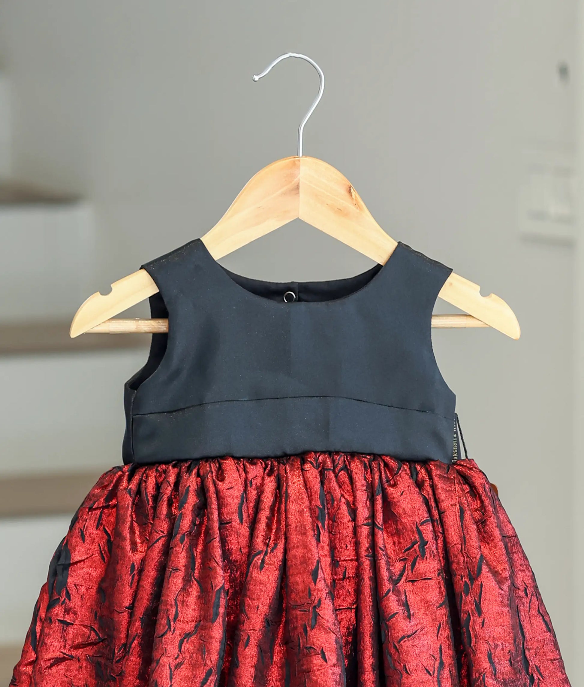Close-up of the plain black bodice and the textured red shimmer crush organza fabric.