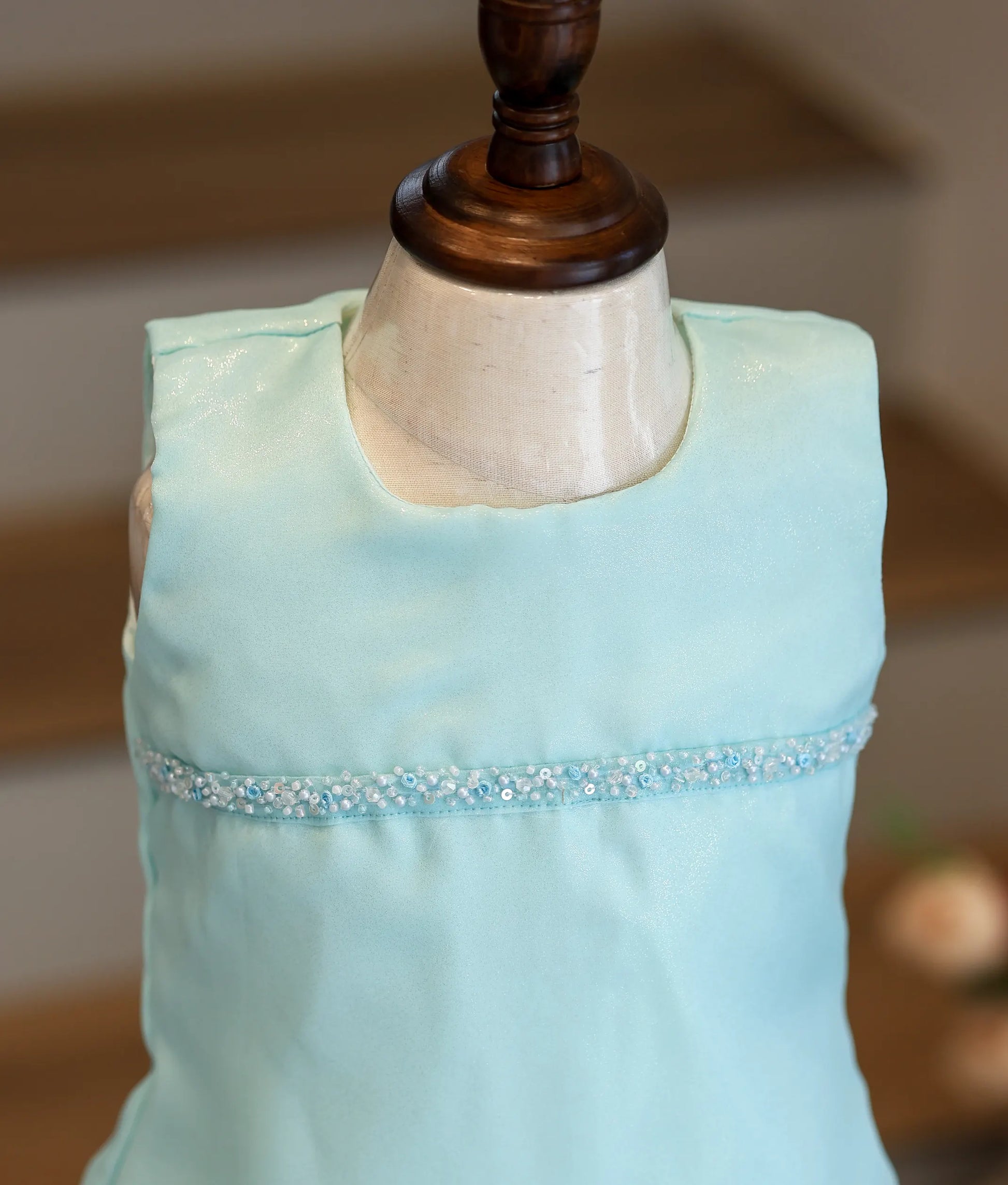 Close-up of the bead and sequin handwork and the shiny organza texture on the sky blue frock.