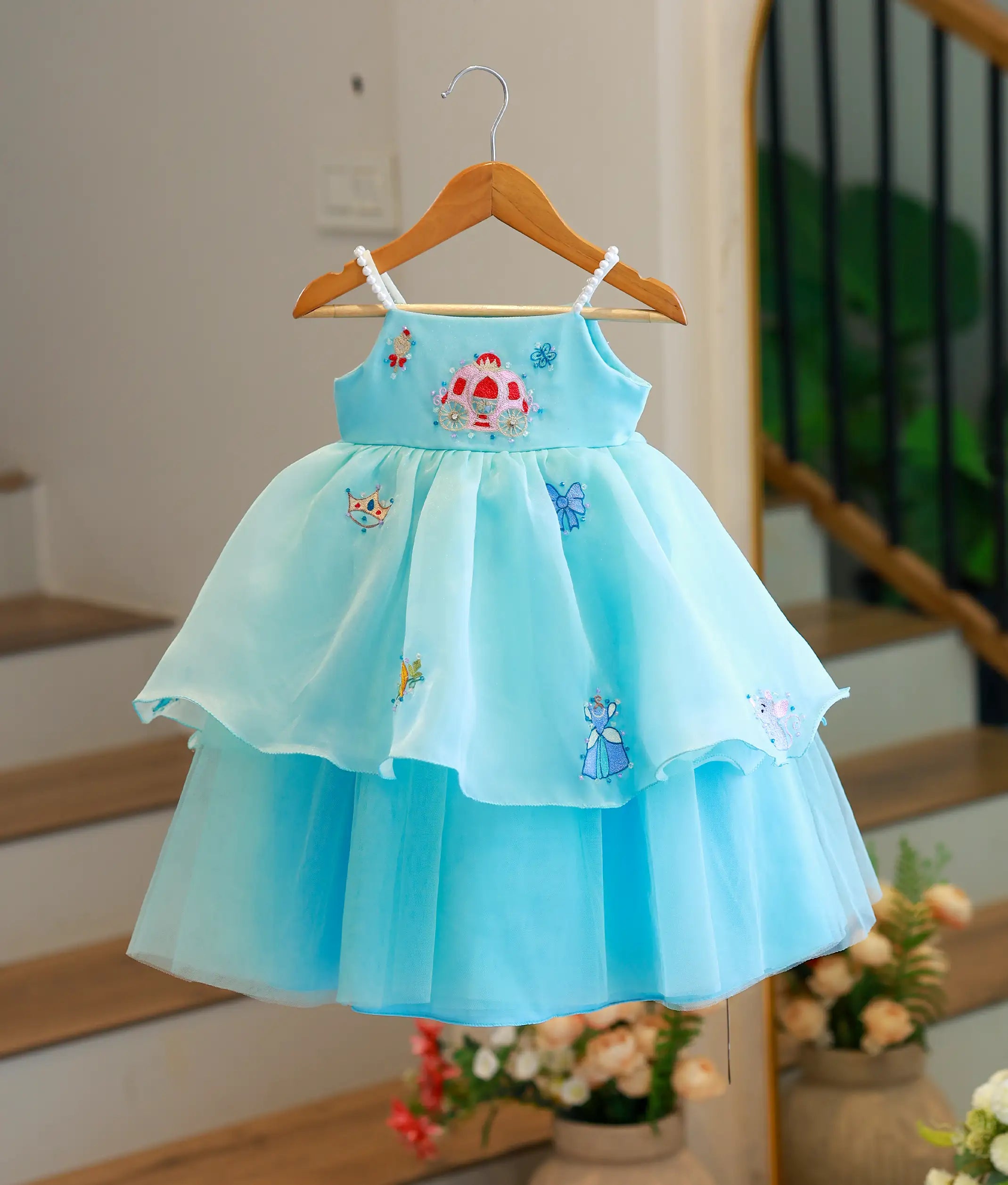Front view of sky blue organza Disney princess theme gown with pearl straps and stepped tiered skirt