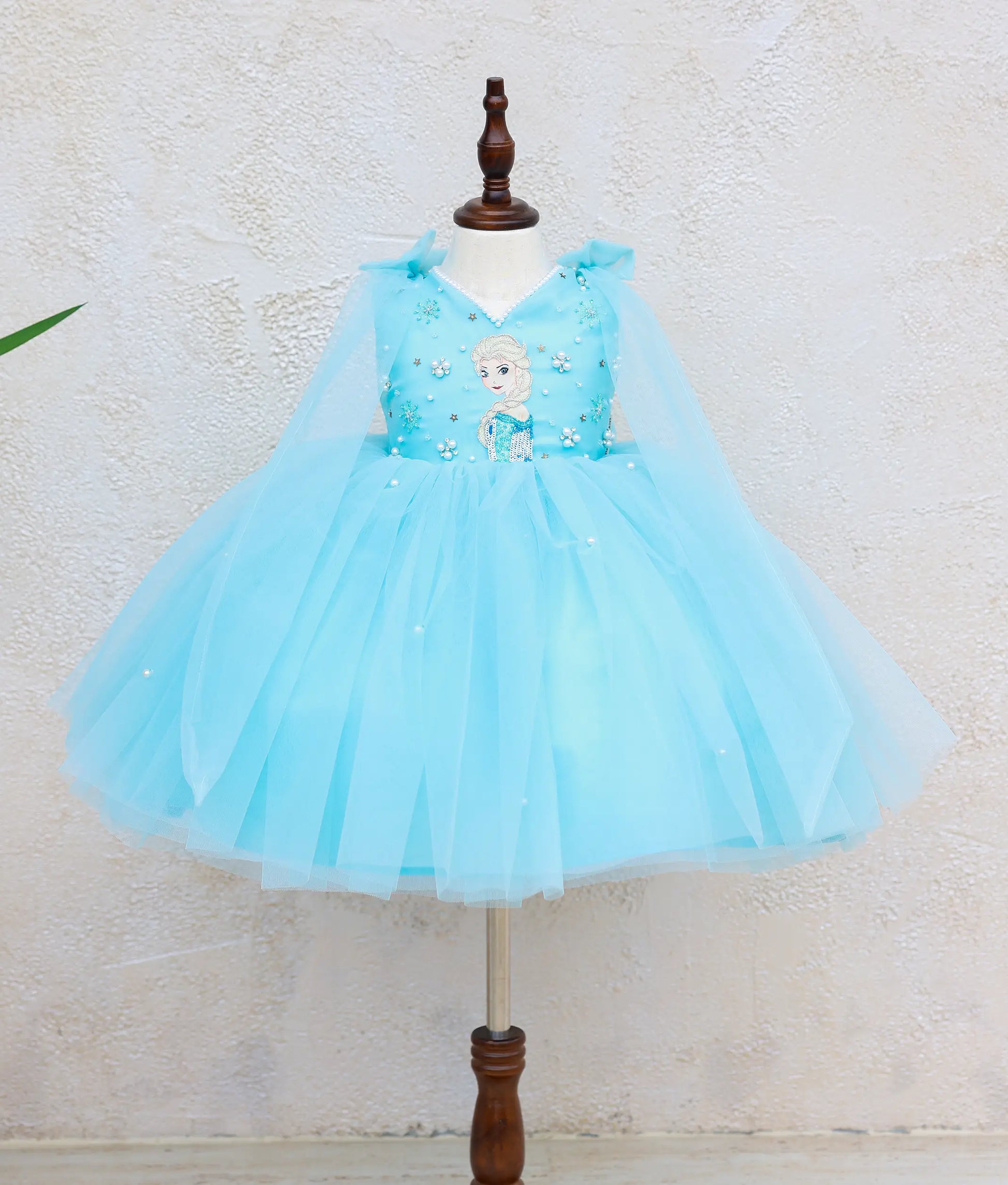 Sky blue Frozen Elsa theme dress for baby girl with handworked Elsa bodice, V-neck, layered tulle skirt with pearl embellishments, and detachable cape.