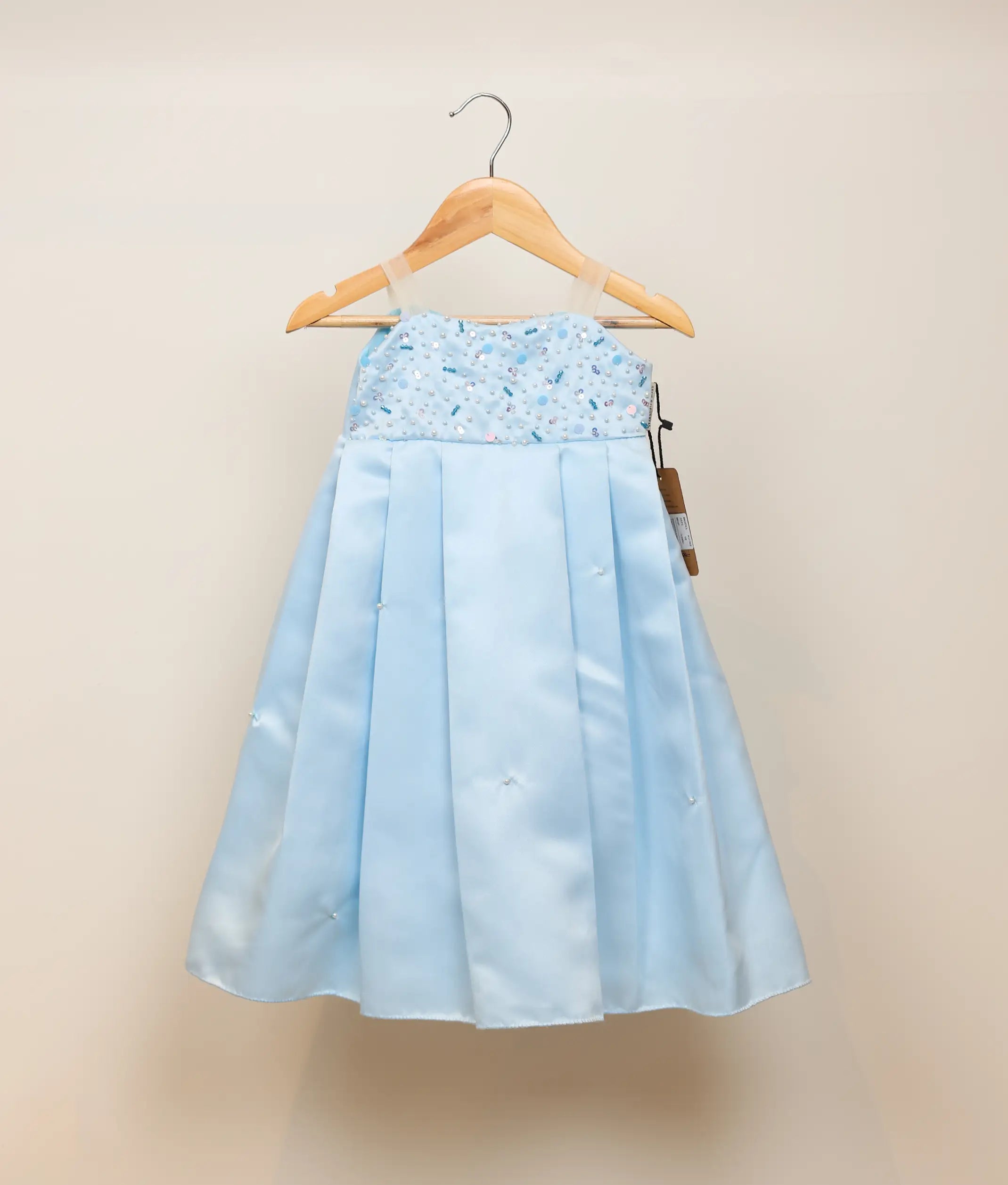 Front view of a sky blue satin organza handworked birthday gown for baby girls with a sequined bodice and pleated skirt