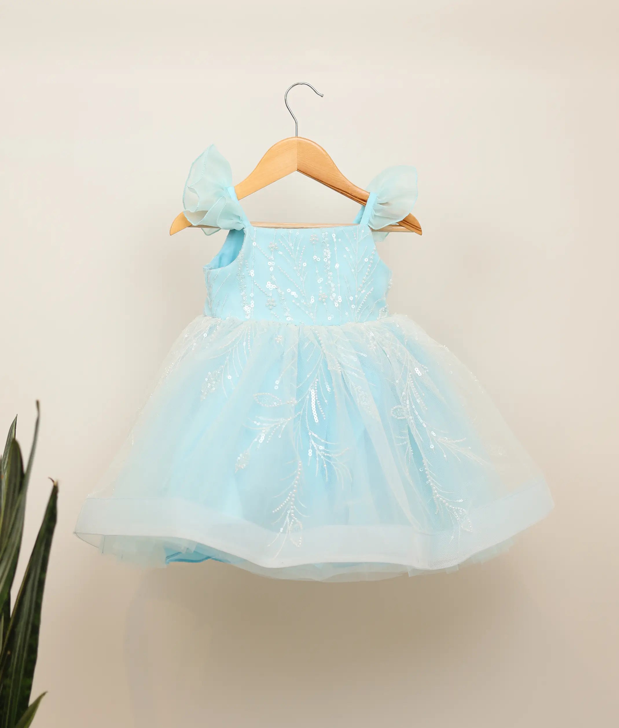 Front view of a sky blue tulle net birthday frock for baby girls featuring floral vine work material and butterfly sleeves
