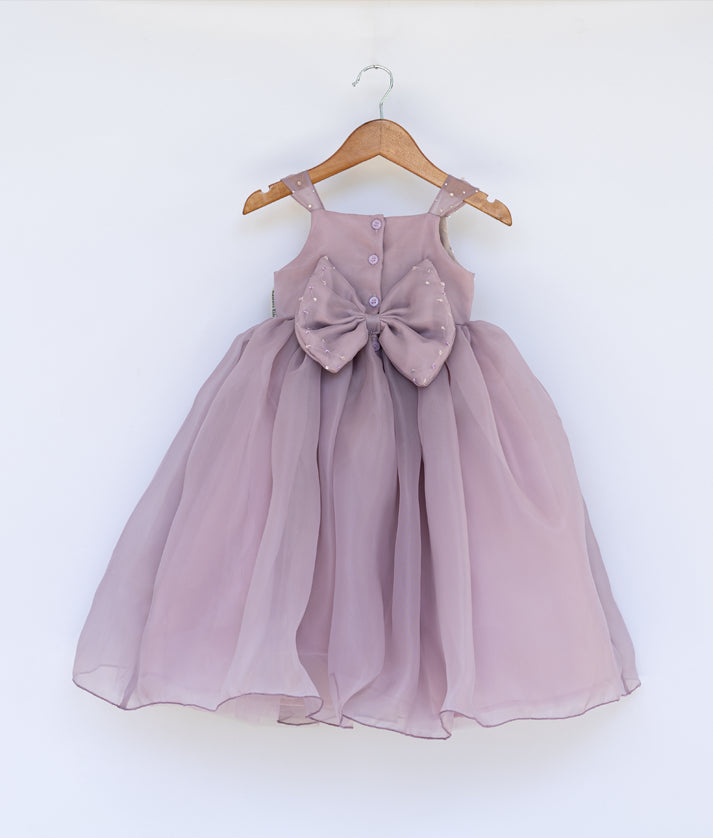 Back view of the pastel lavender gown featuring a square neck design and a decorative back bow