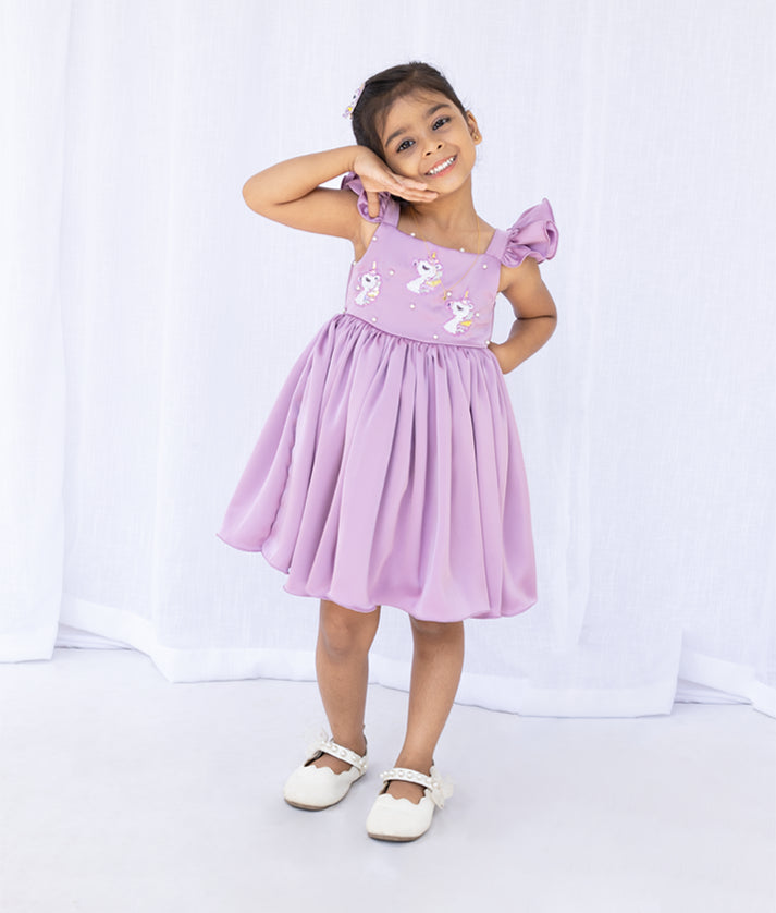 Back view of the lavender unicorn theme dress highlighting the square back neck and puff ruffle shoulder details