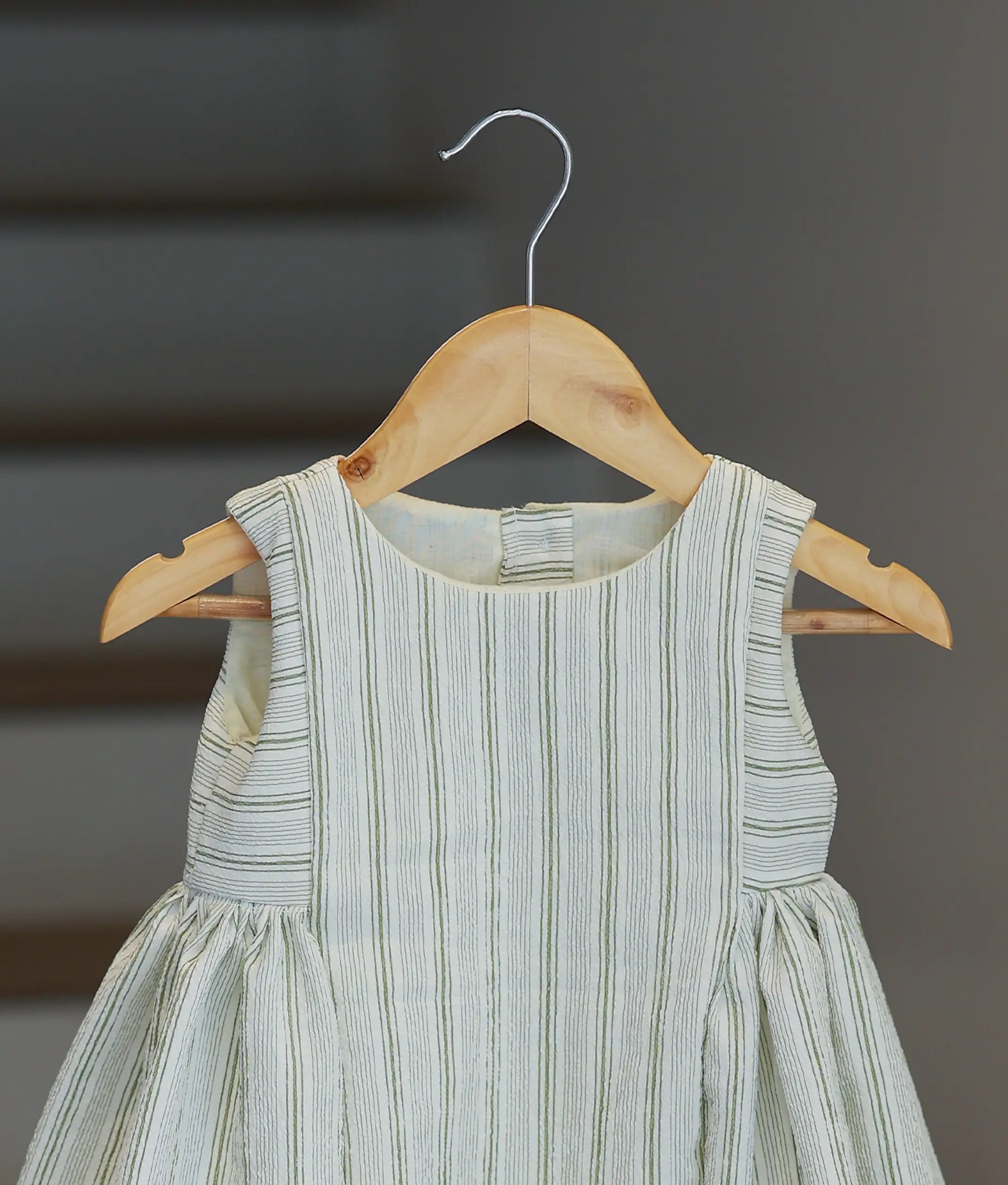 A close-up view of the bodice and round neckline of the green and white striped crush crape frock