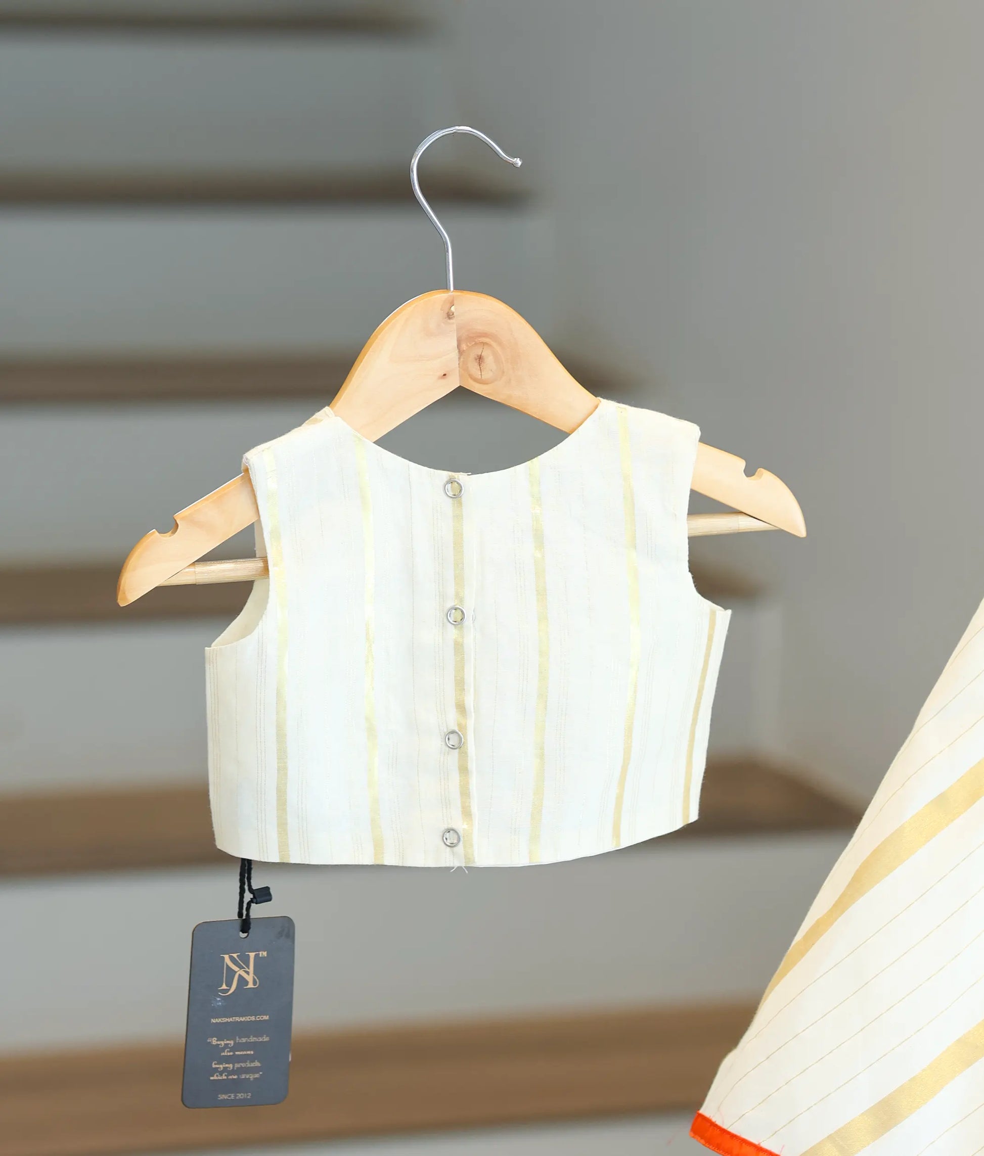 Back view of the off-white top showing the button closure.