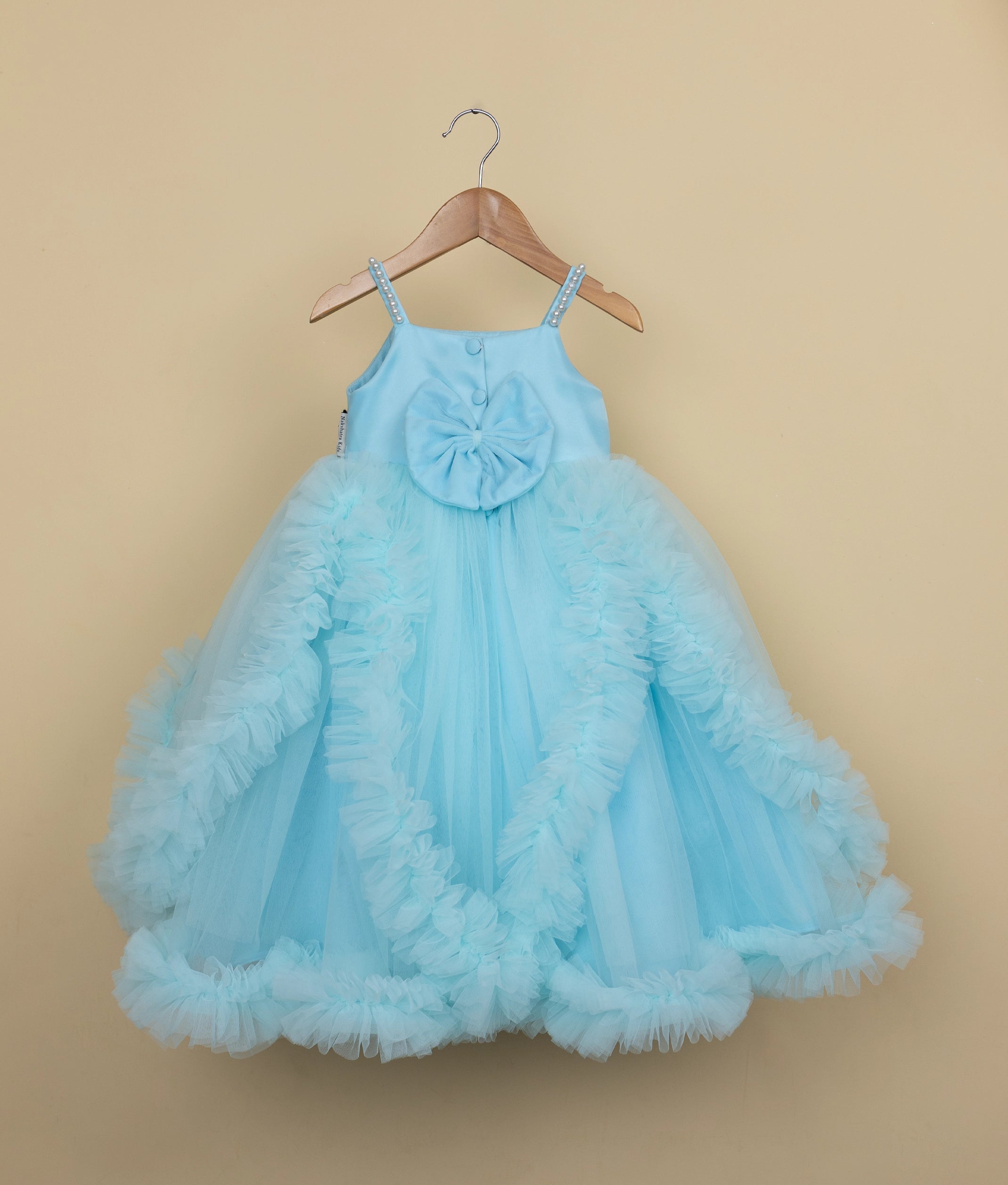 Back view of toddler blue frock with cascading ruffle layers and voluminous skirt