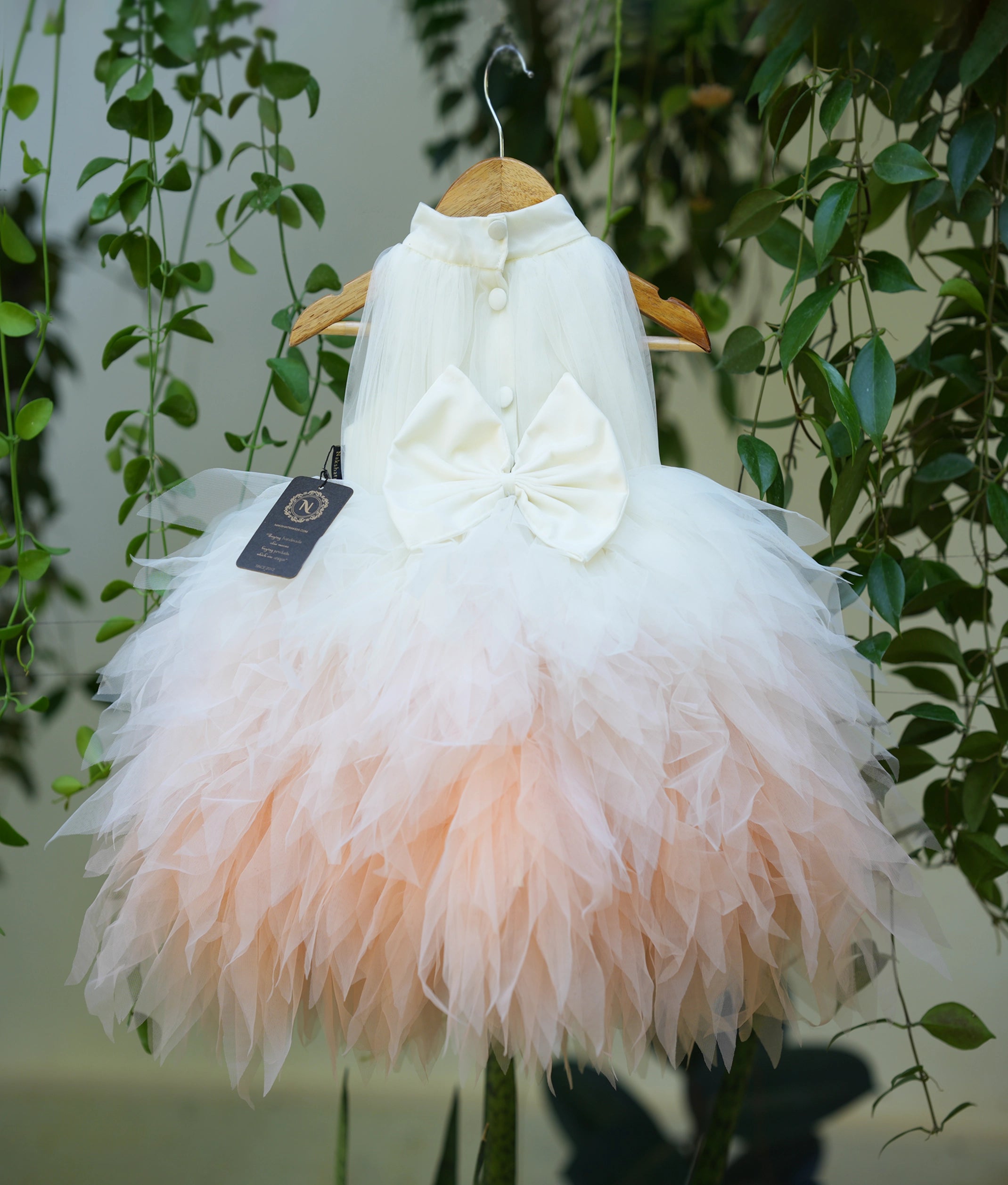 Side angle view of toddler feather frock showing white bodice and pink feather tutu layers