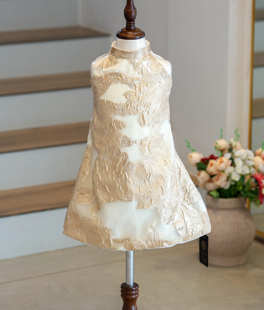 Front view of a cream and gold Turkish organza A-line frock with a high-neck halter.