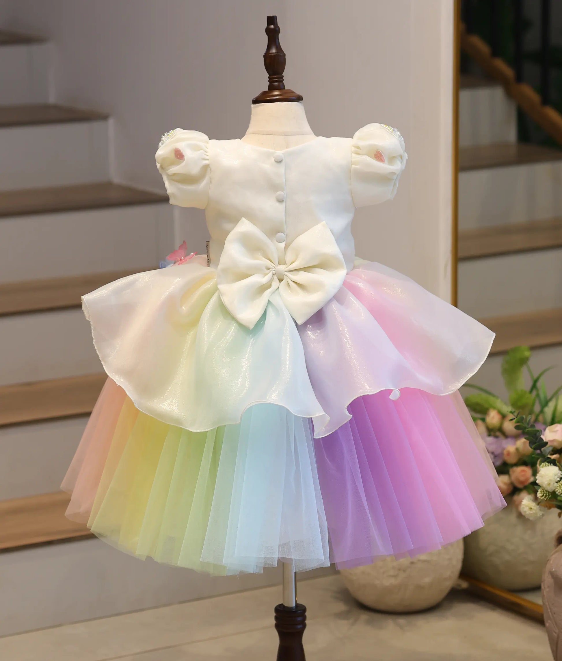 Back view of the girls unicorn party frock showing the fit of the bodice and the flow of the multi-layered rainbow tulle bottom.