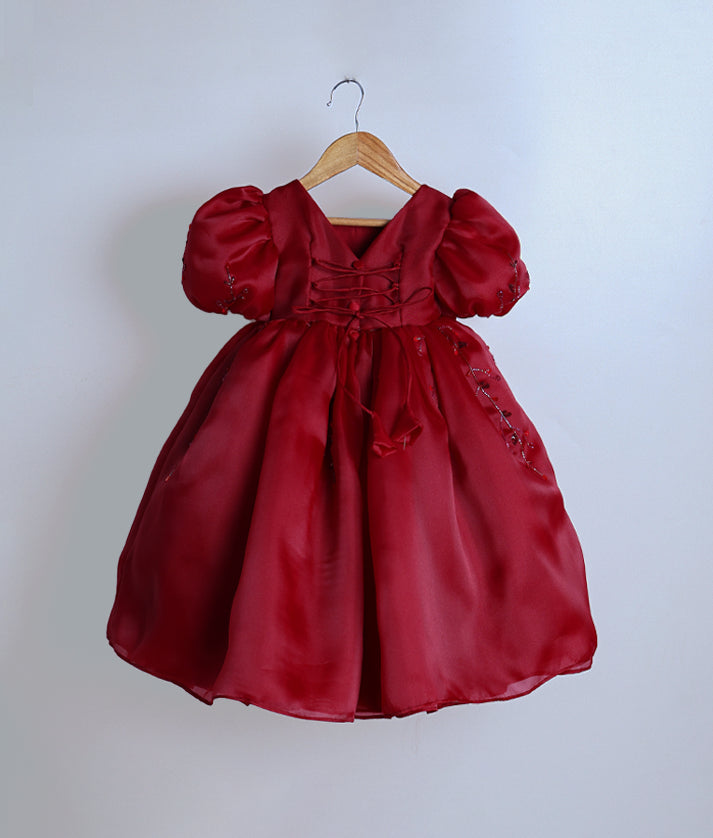 Back view of the maroon organza gown highlighting the V-neckline and elegant tie-back closure