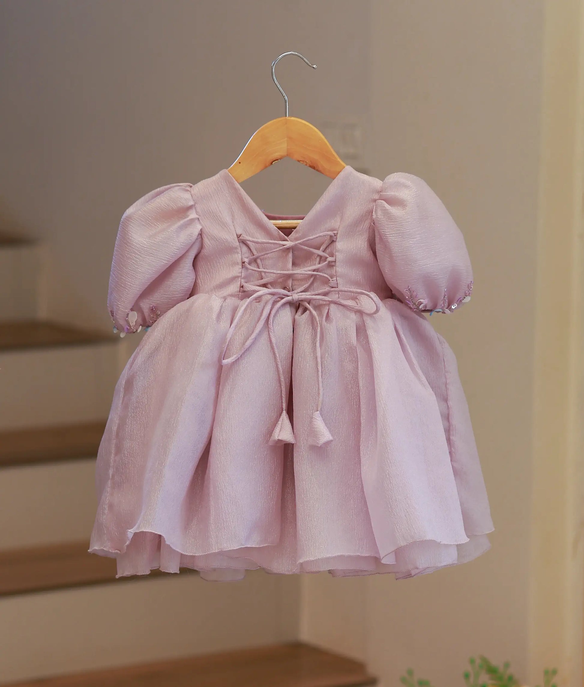 Back view of the pastel lavender organza frock featuring a V-neckline with a press button closure and fabric tie-up