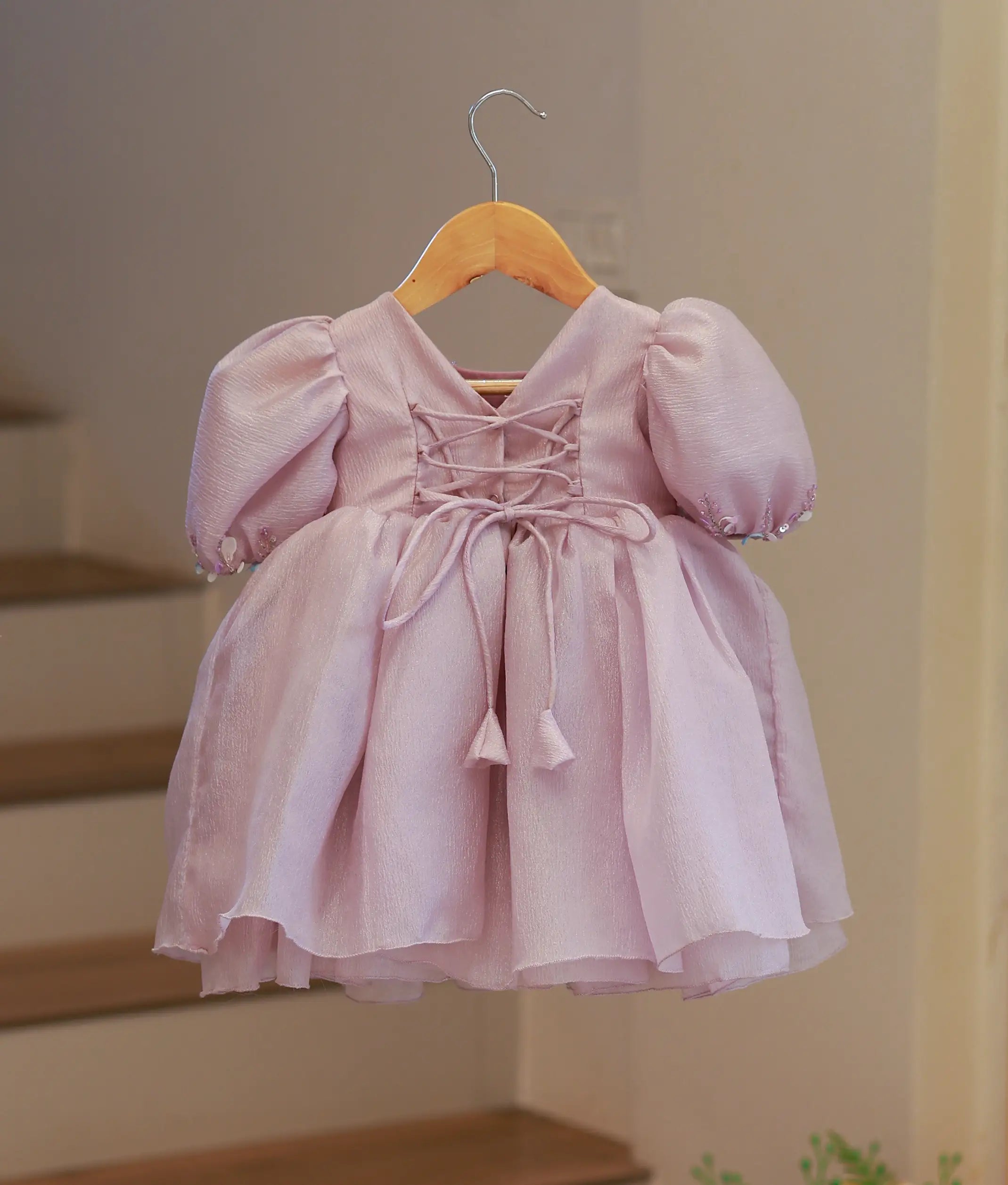 Back view of the pastel lavender organza frock featuring a V-neckline with a press button closure and fabric tie-up