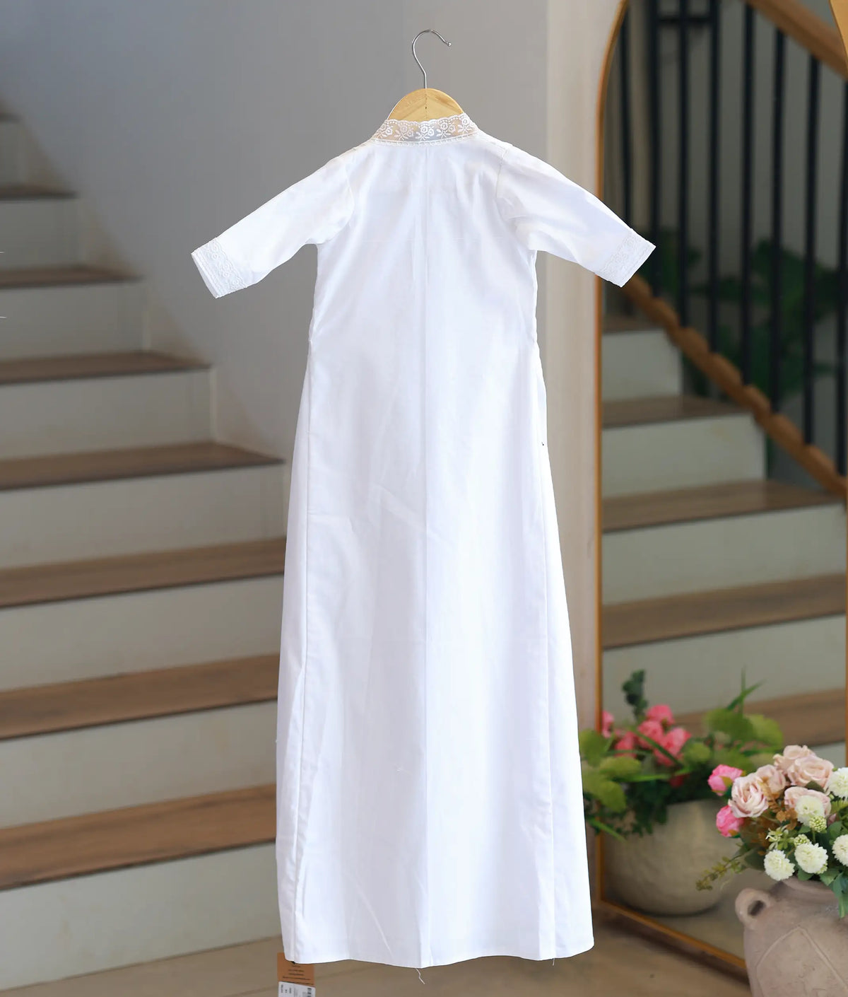 Full back view off white cotton baby baptism gown displaying a lace-trimmed back collar and elbow-length sleeves.