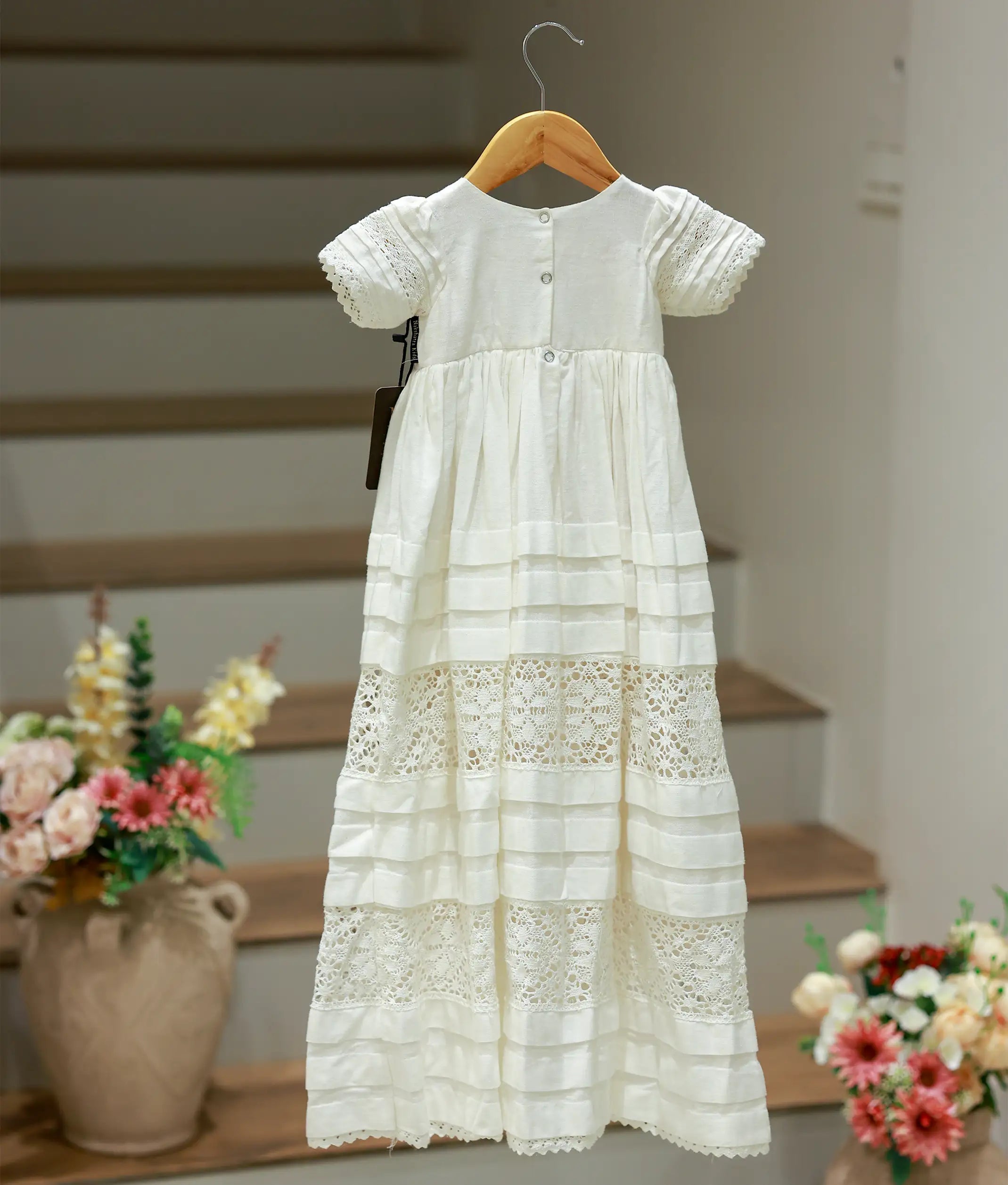 Back view of the white baptism dress highlighting the button closure 