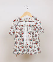 White floral printed cotton frock for baby girl, full front view showing flared skirt and puff sleeves.