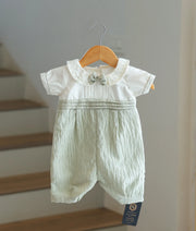 Front view of a white and pastel green baby boy baptism romper set with a bow tie.