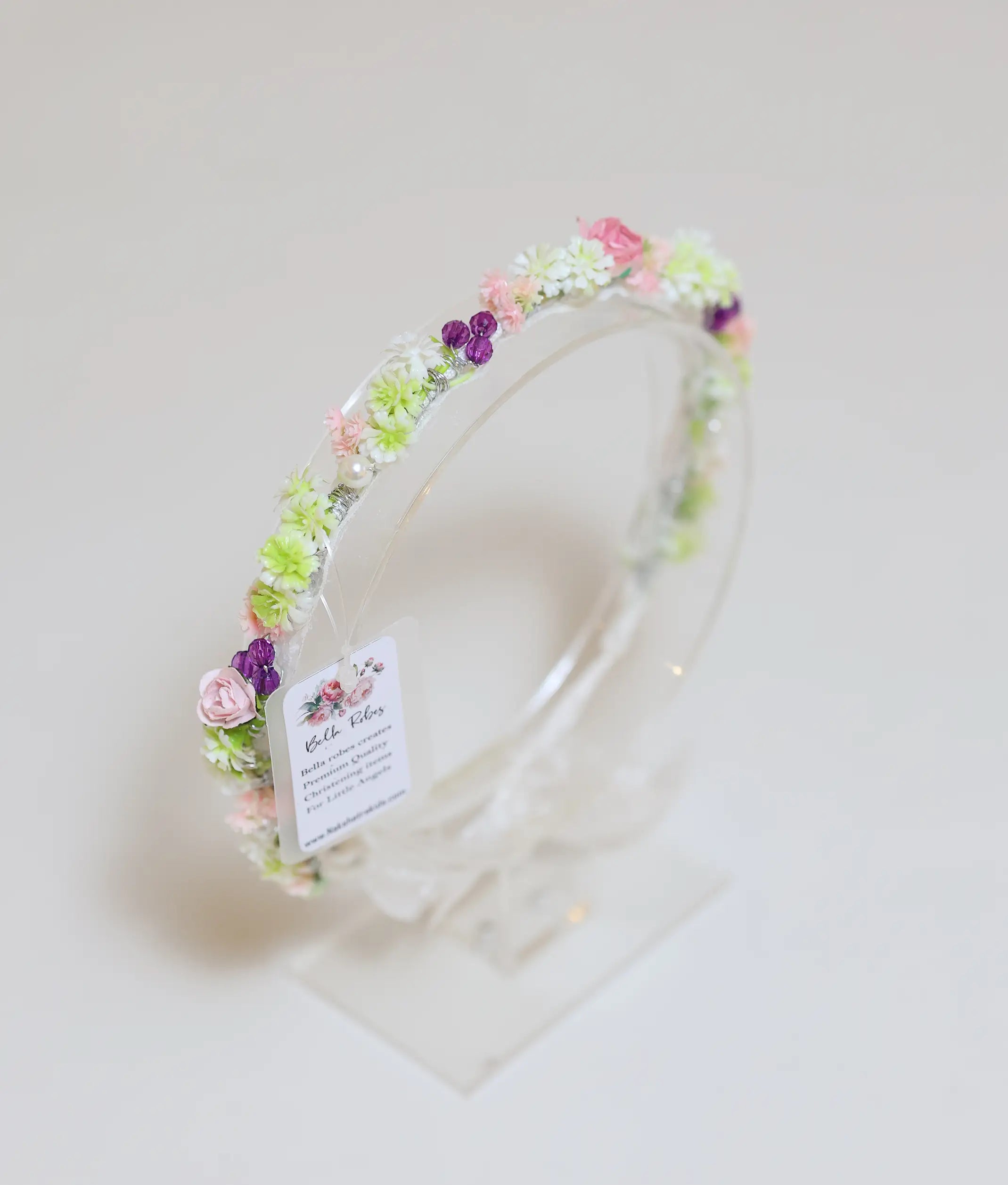 Front view of a white and pink rose floral handmade tiara for girls with a white ribbon tie