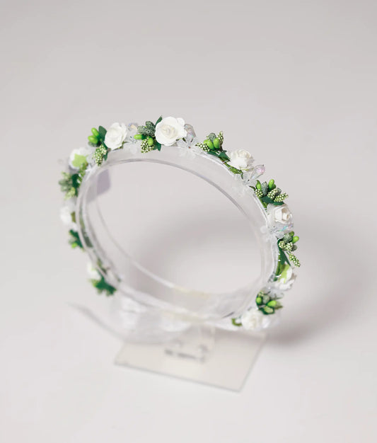 Close-up of the handmade tiara showing detailed white roses, green bud clusters, and shimmering crystal beads