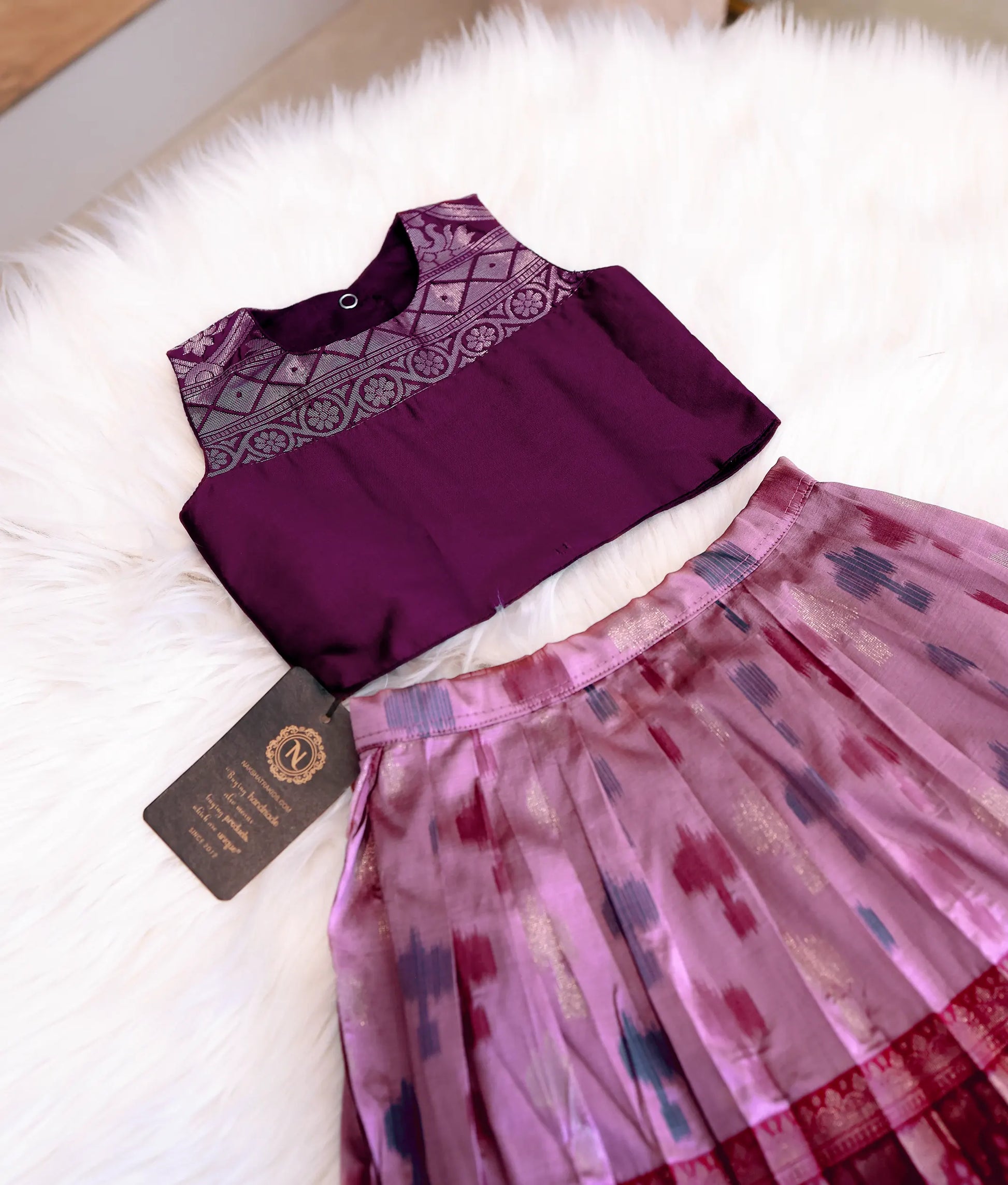 Close-up of the golden zari patterns on the neck and shoulders of the wine silk top.