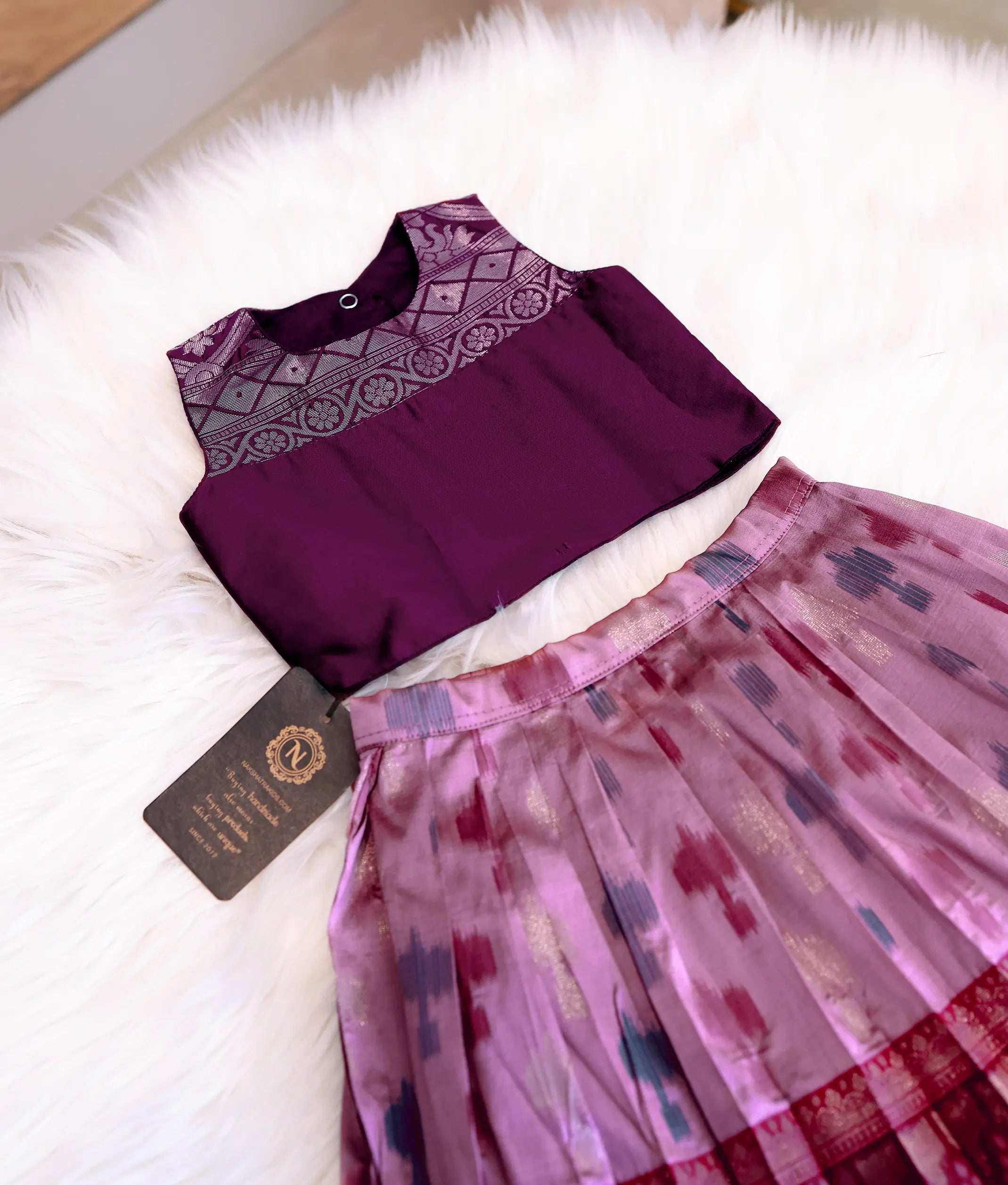 Close-up of the golden zari patterns on the neck and shoulders of the wine silk top.