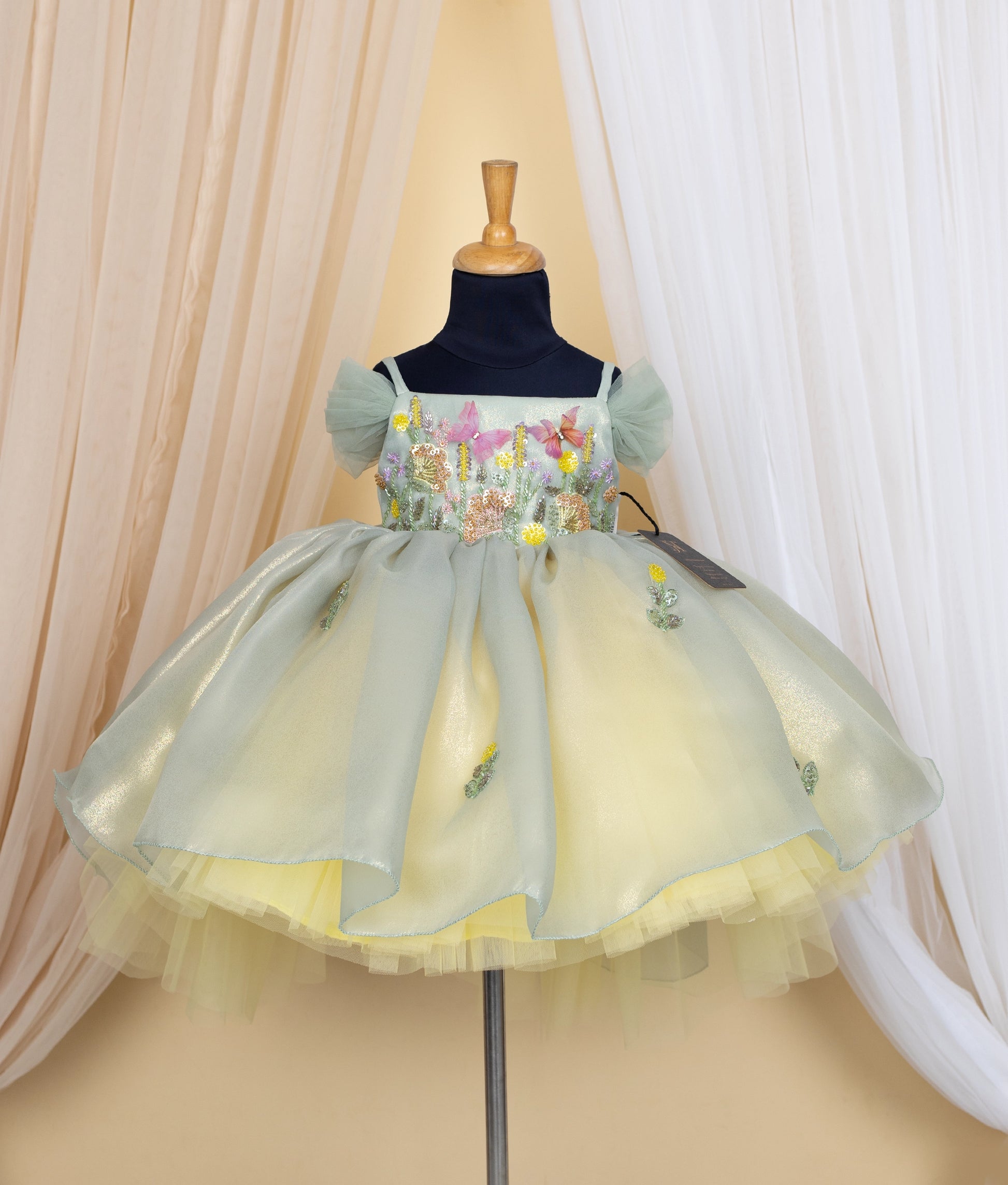 Pastel green and yellow frock displayed on mannequin.